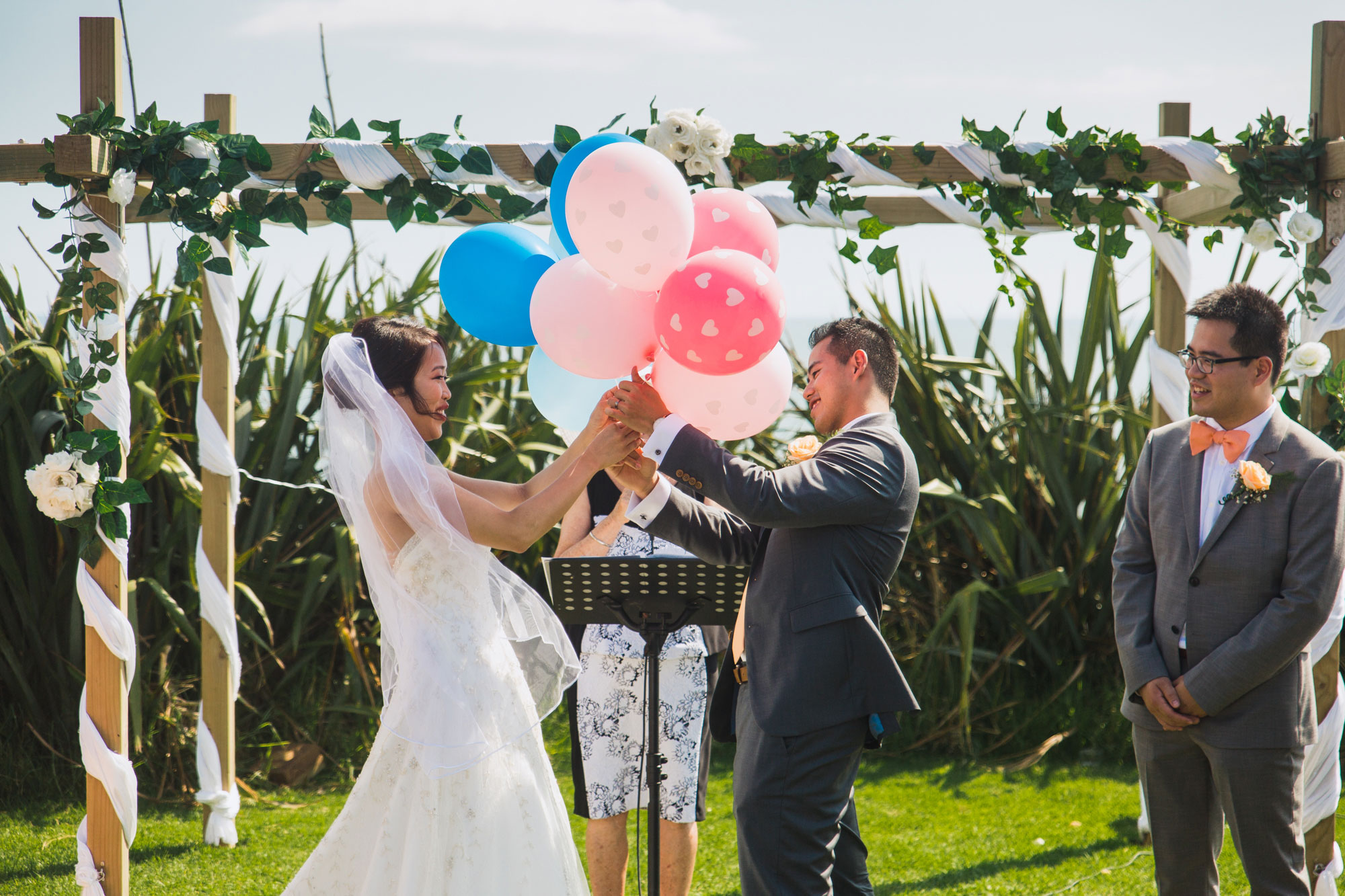bride and groom holding onto balloons