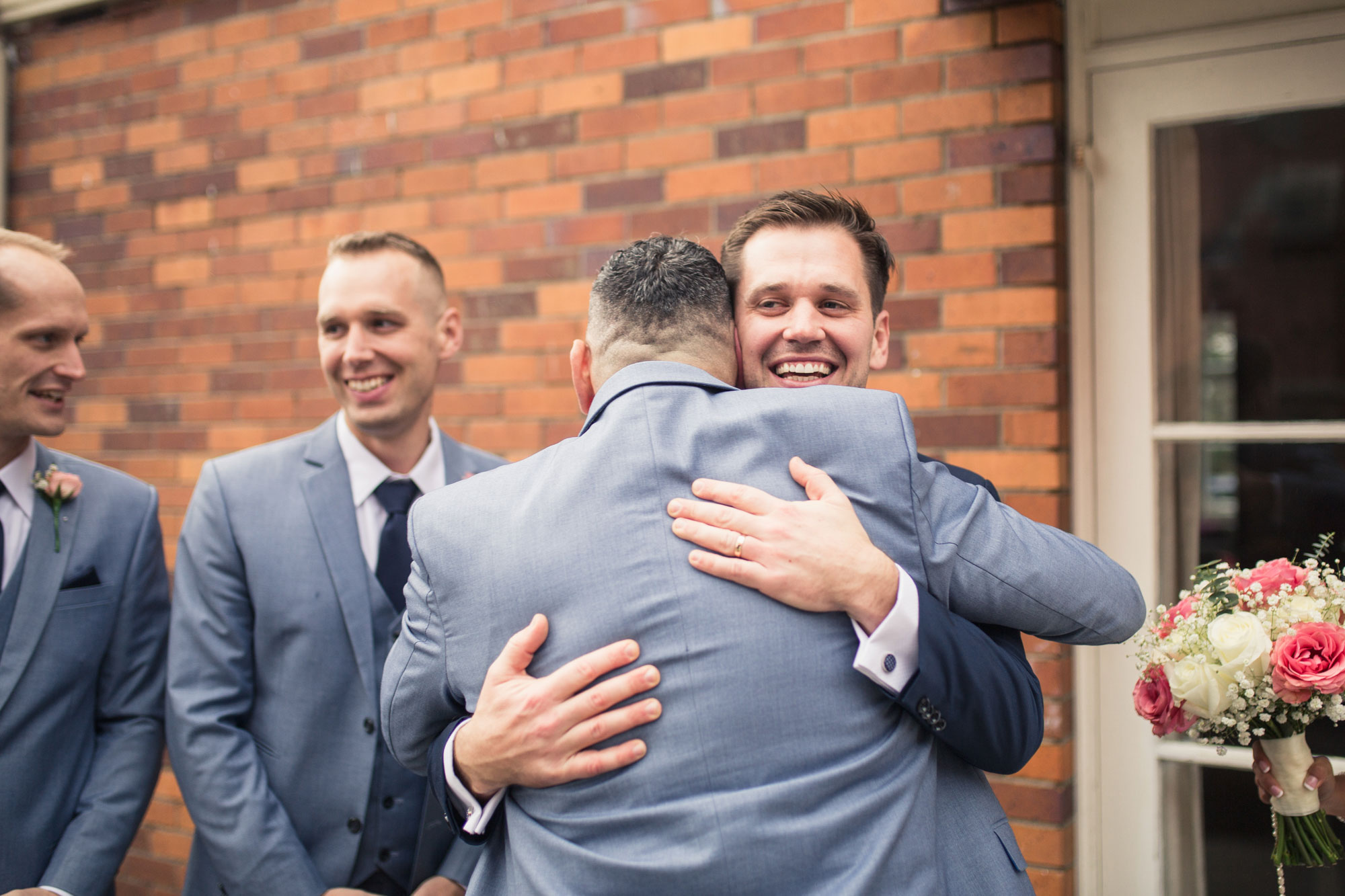 groom hugging a guest