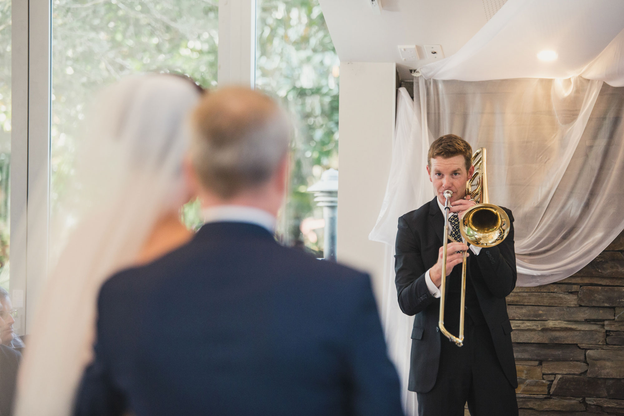bride and groom looking at musician