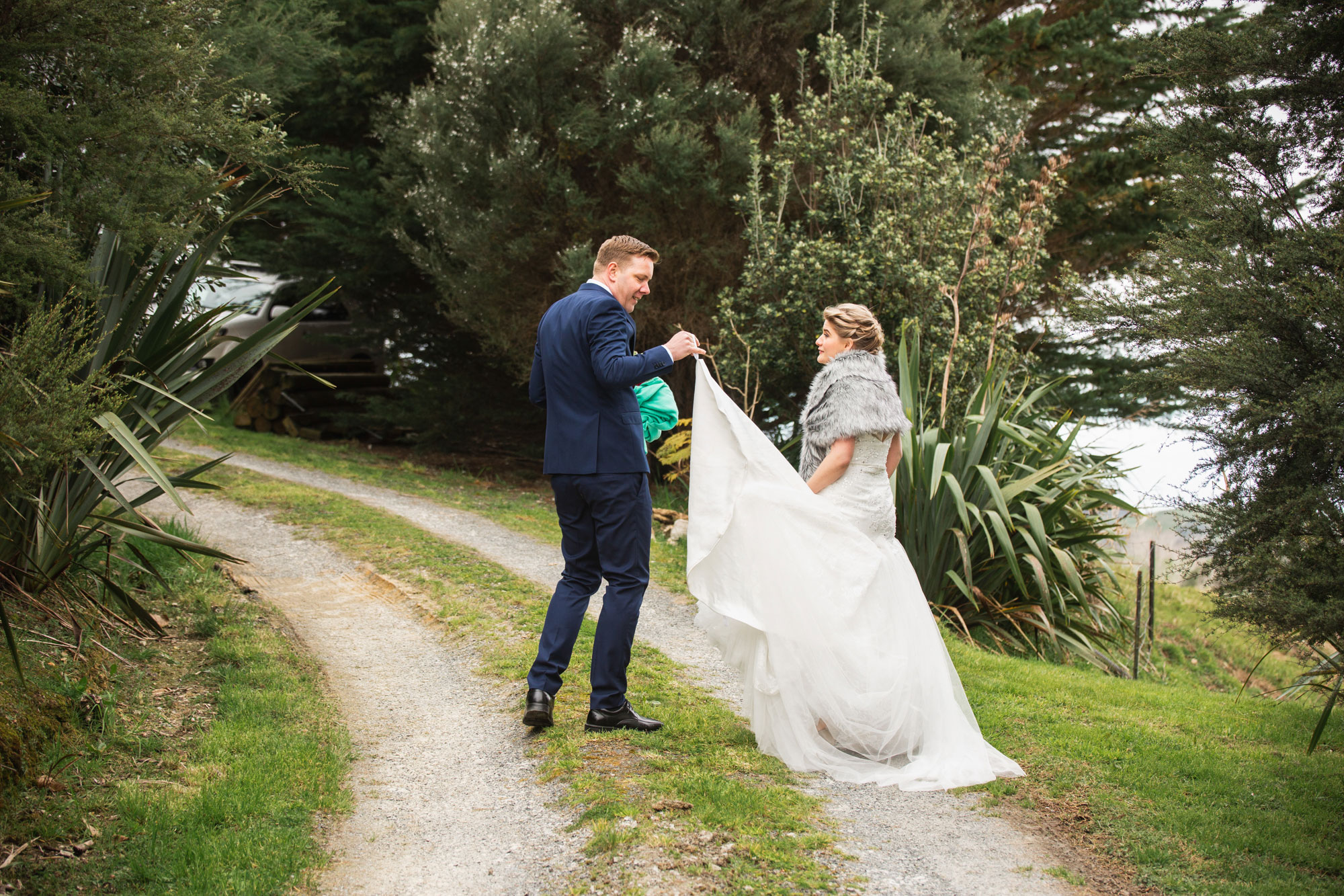 groom holding bride's dress