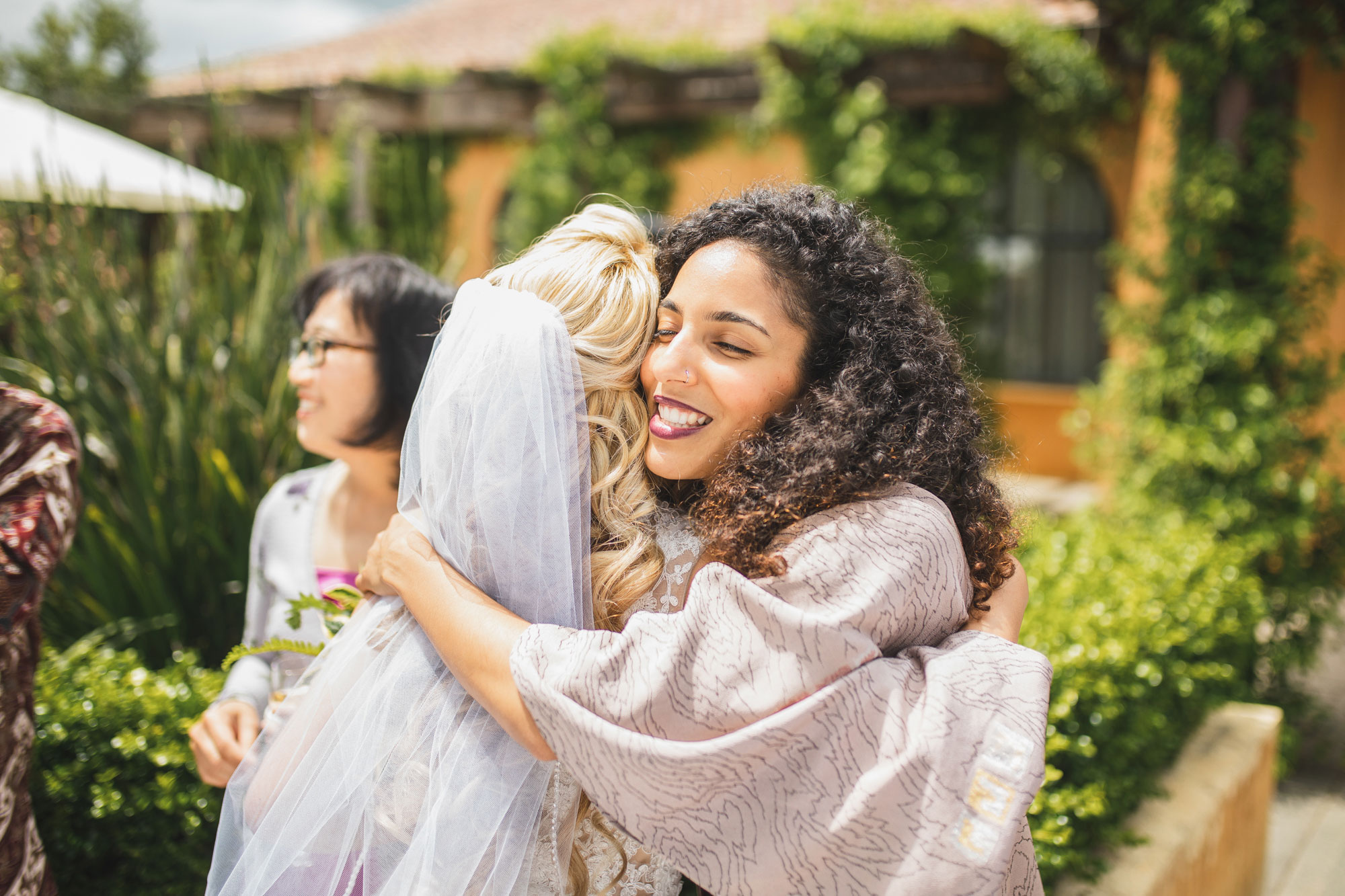 auckland wedding guest hugging bride