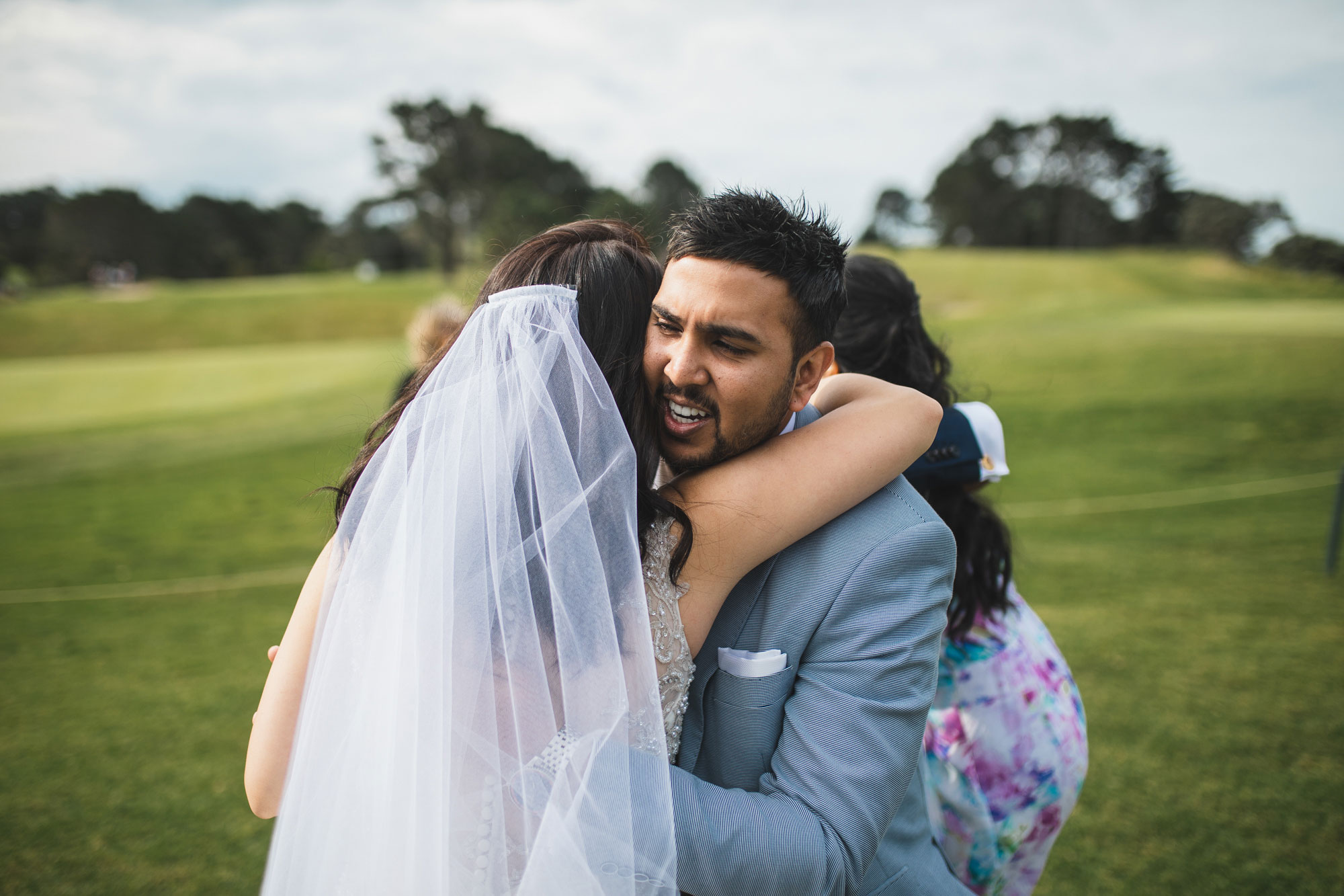 auckland wedding guest hugging bride