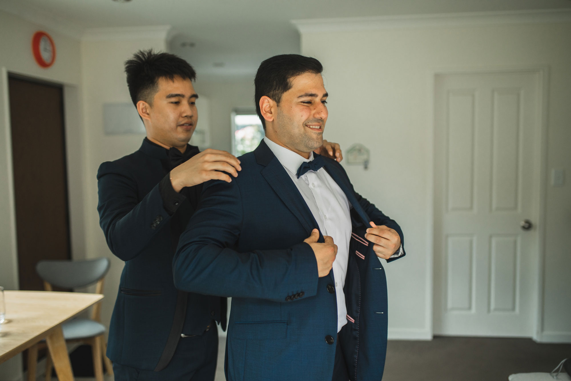 auckland groom putting on suit