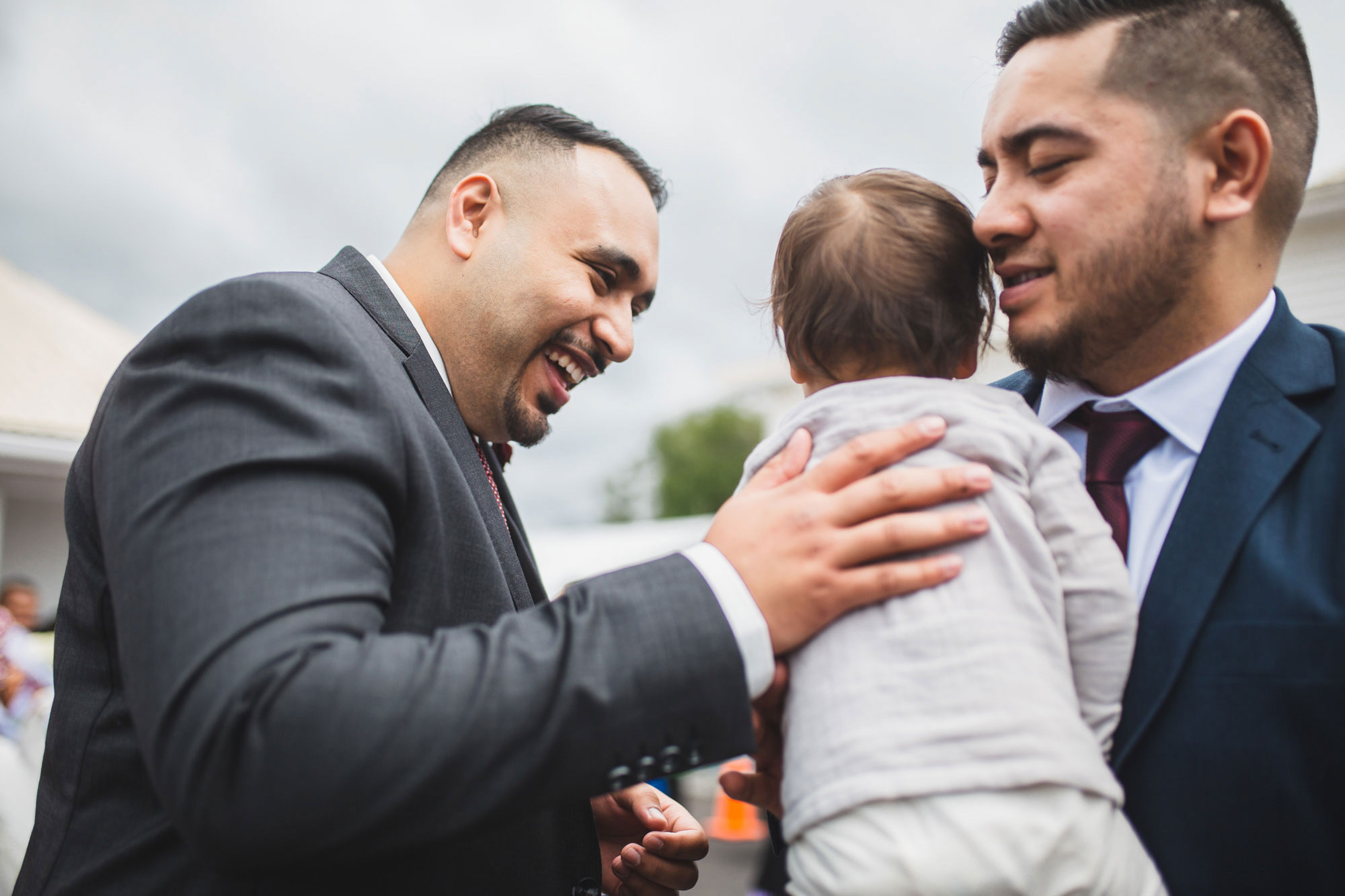 groom patting a baby auckland wedding