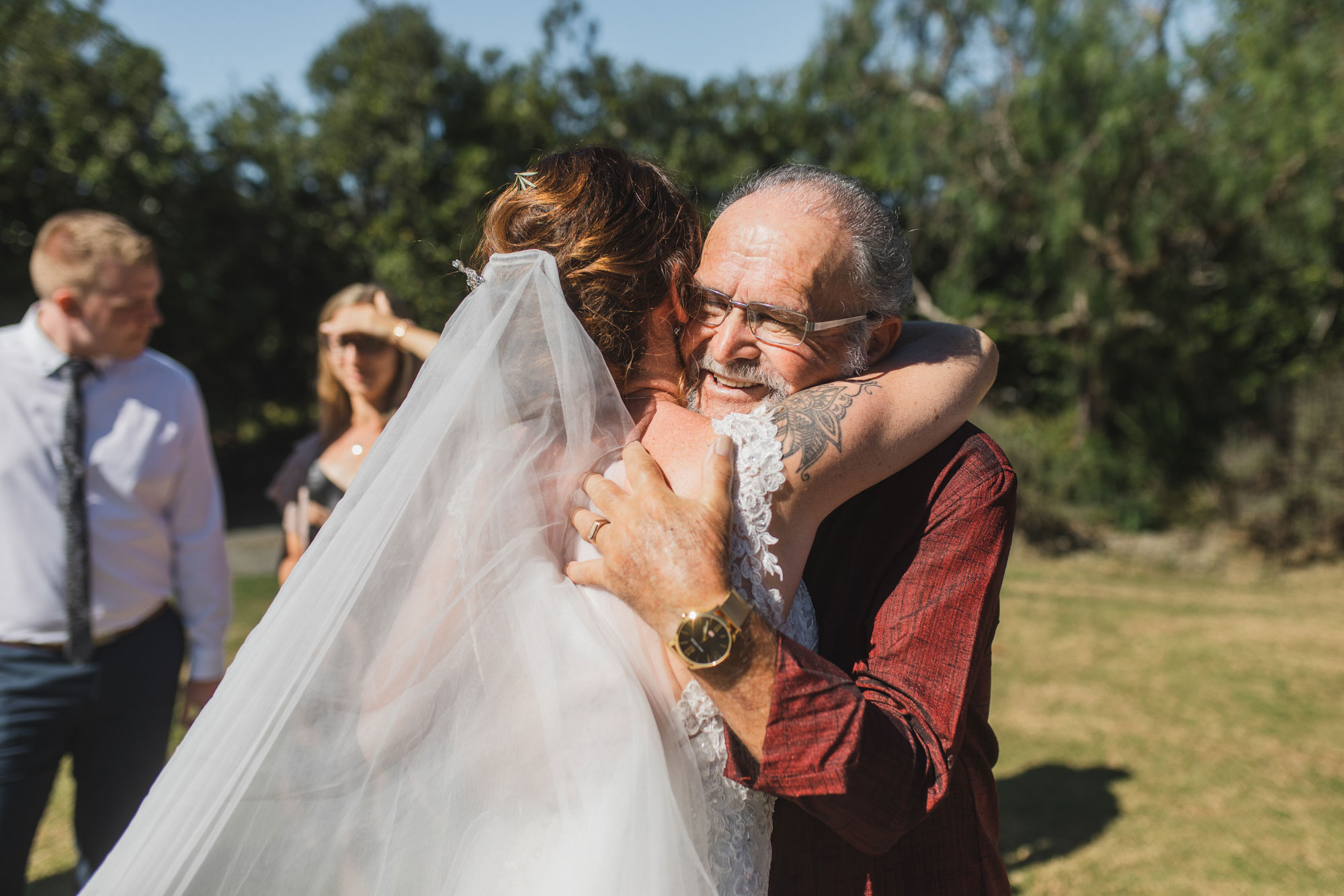 auckland tawharanui lodge wedding guest embracing bride