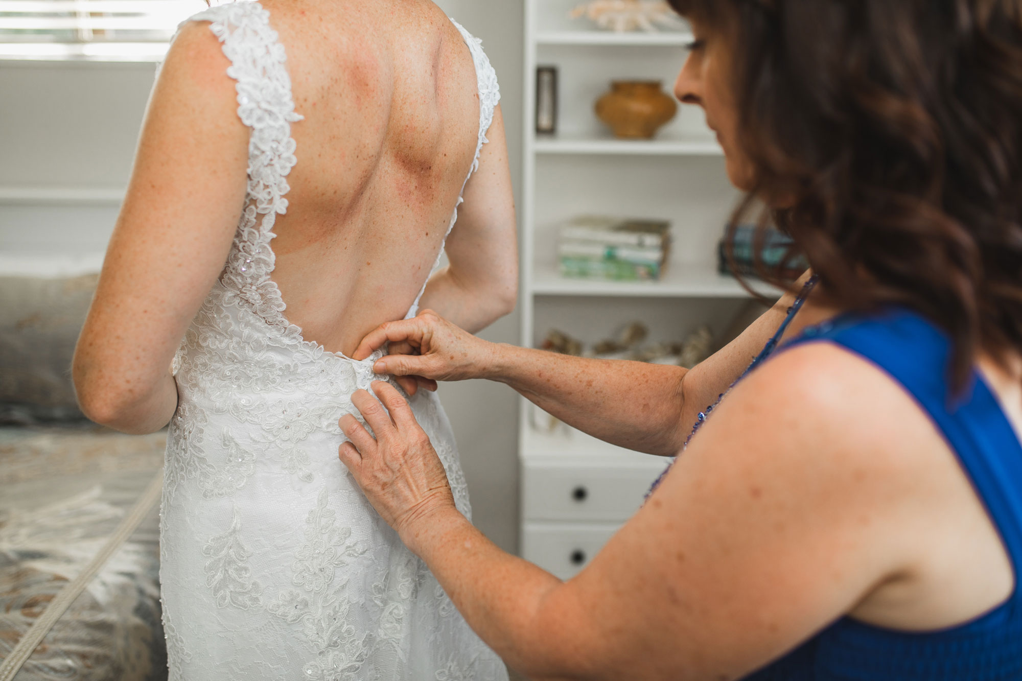 auckland wedding bride putting on dress