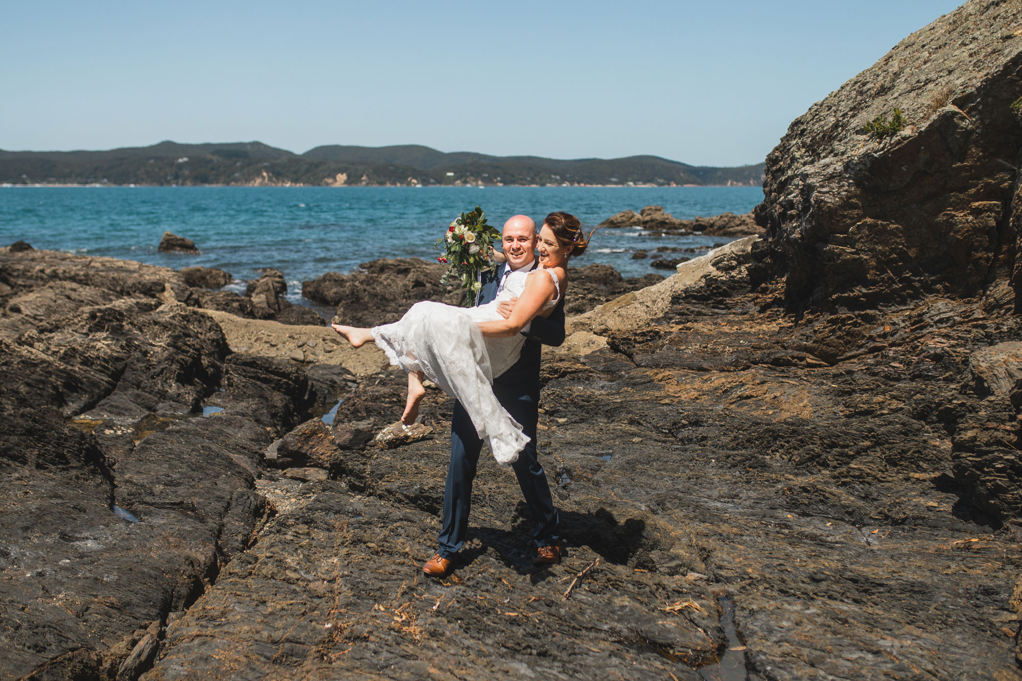 groom carrying bride photo