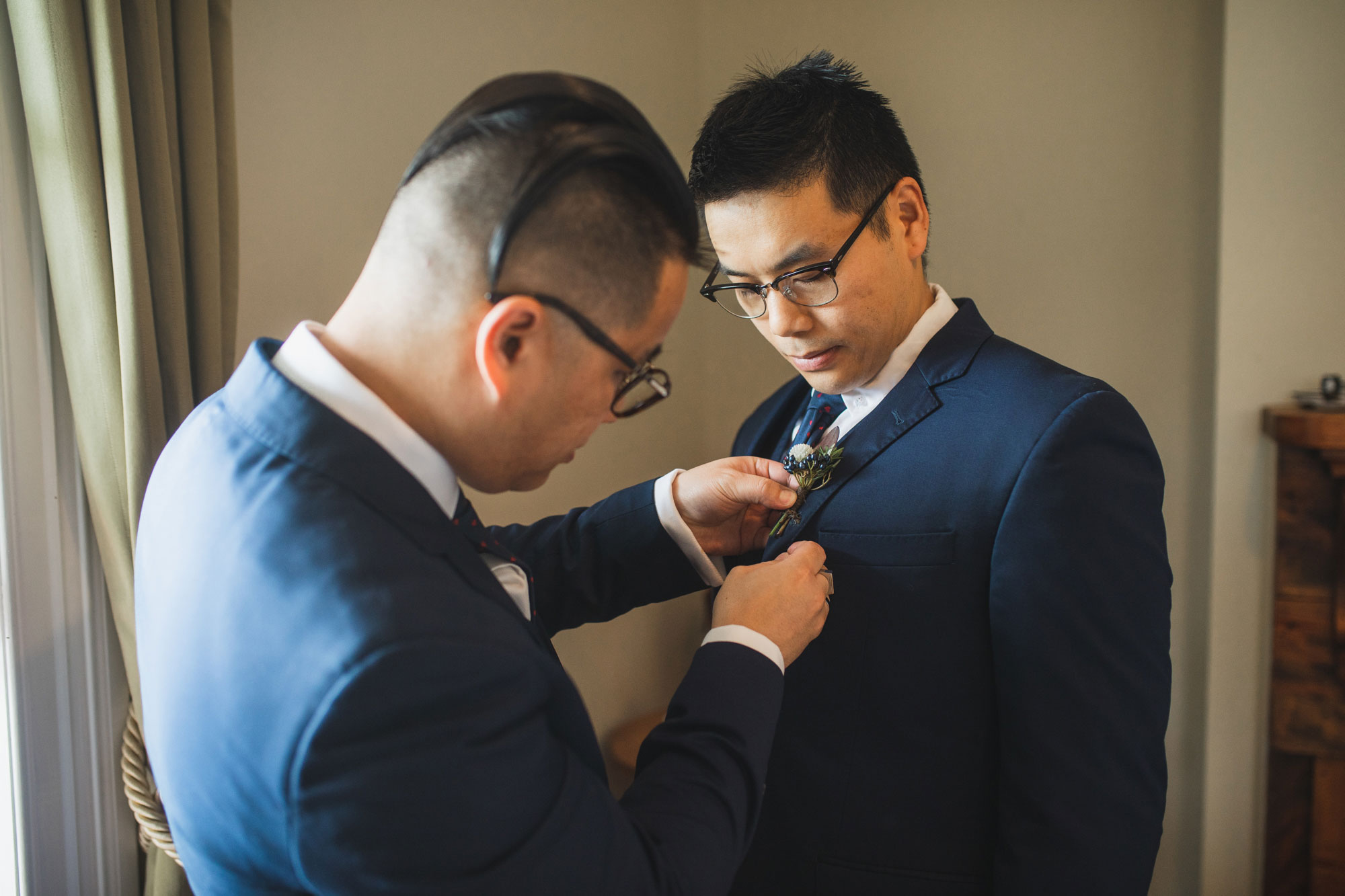 auckland wedding groomsmen putting on flowers