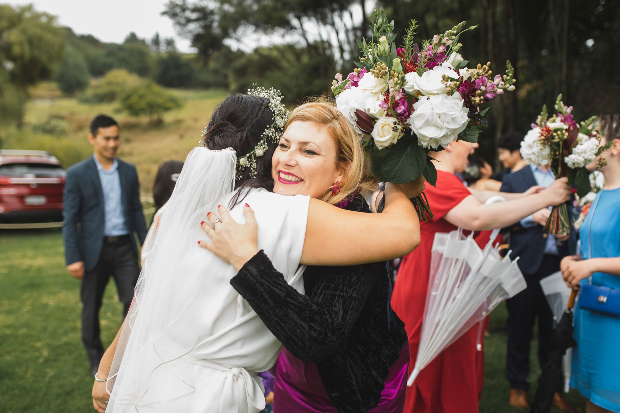 auckland waterfall farm wedding guest hugging bride