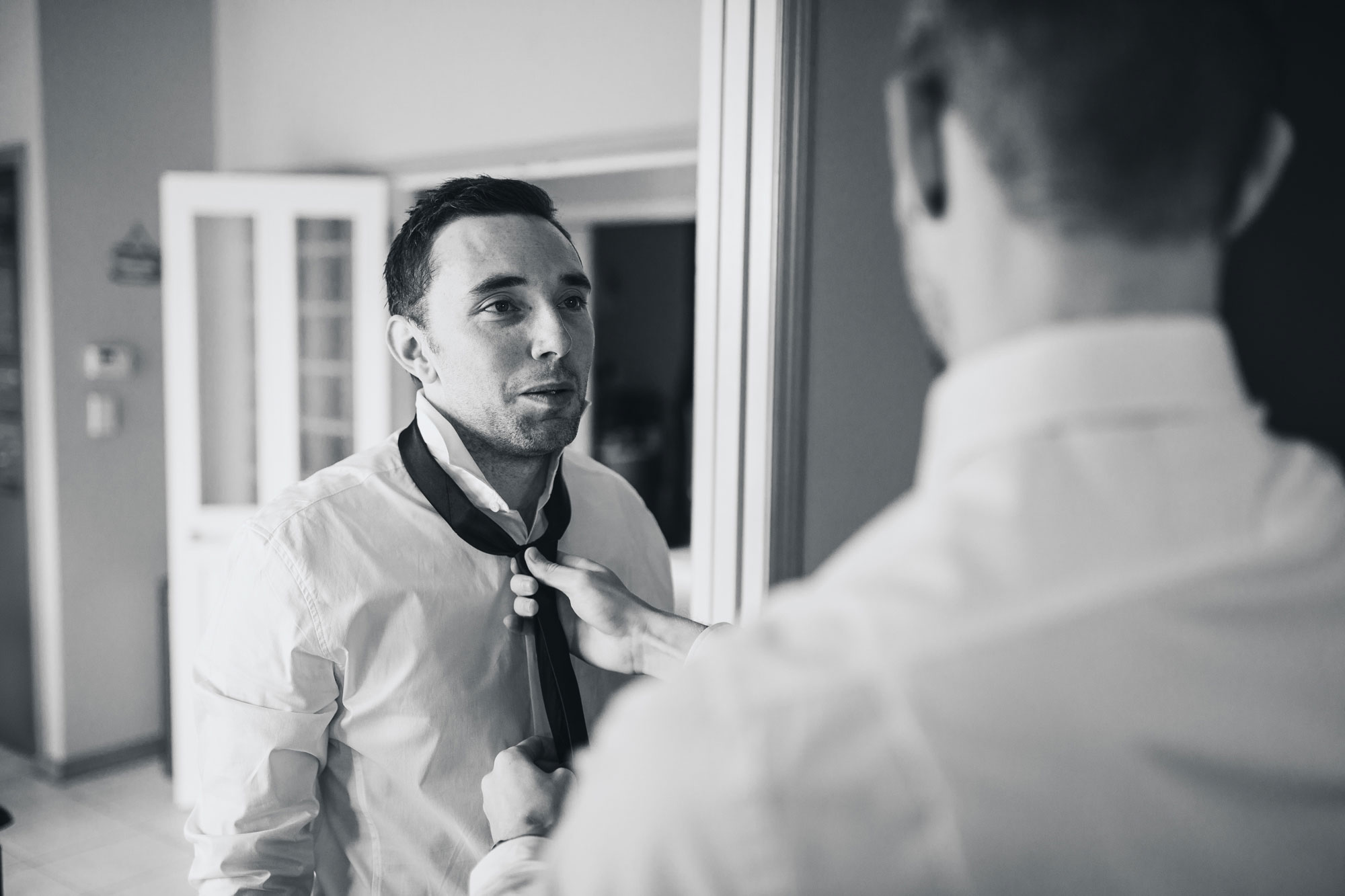 groomsman putting on tie