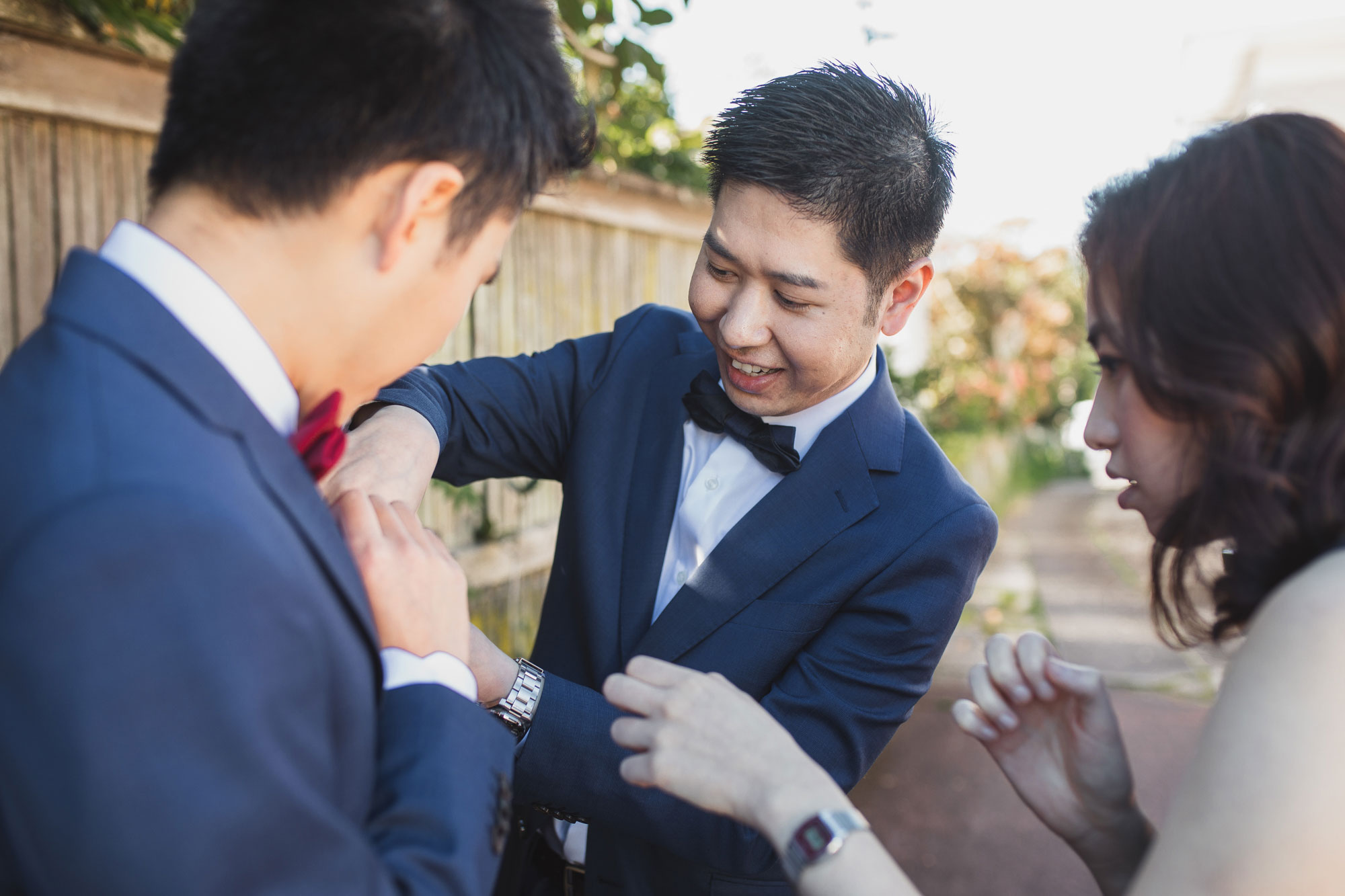 best man putting on flowers for groom