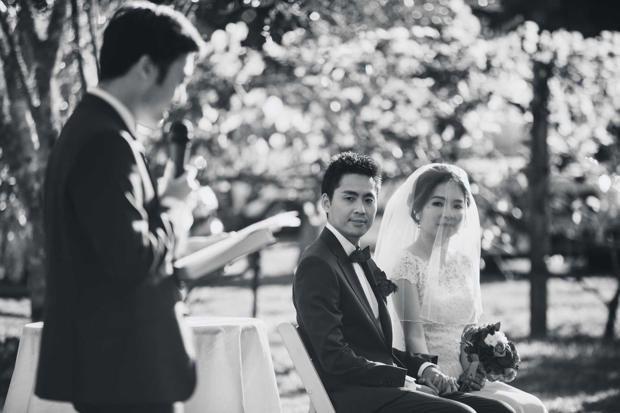 bride and groom listening to the emcee