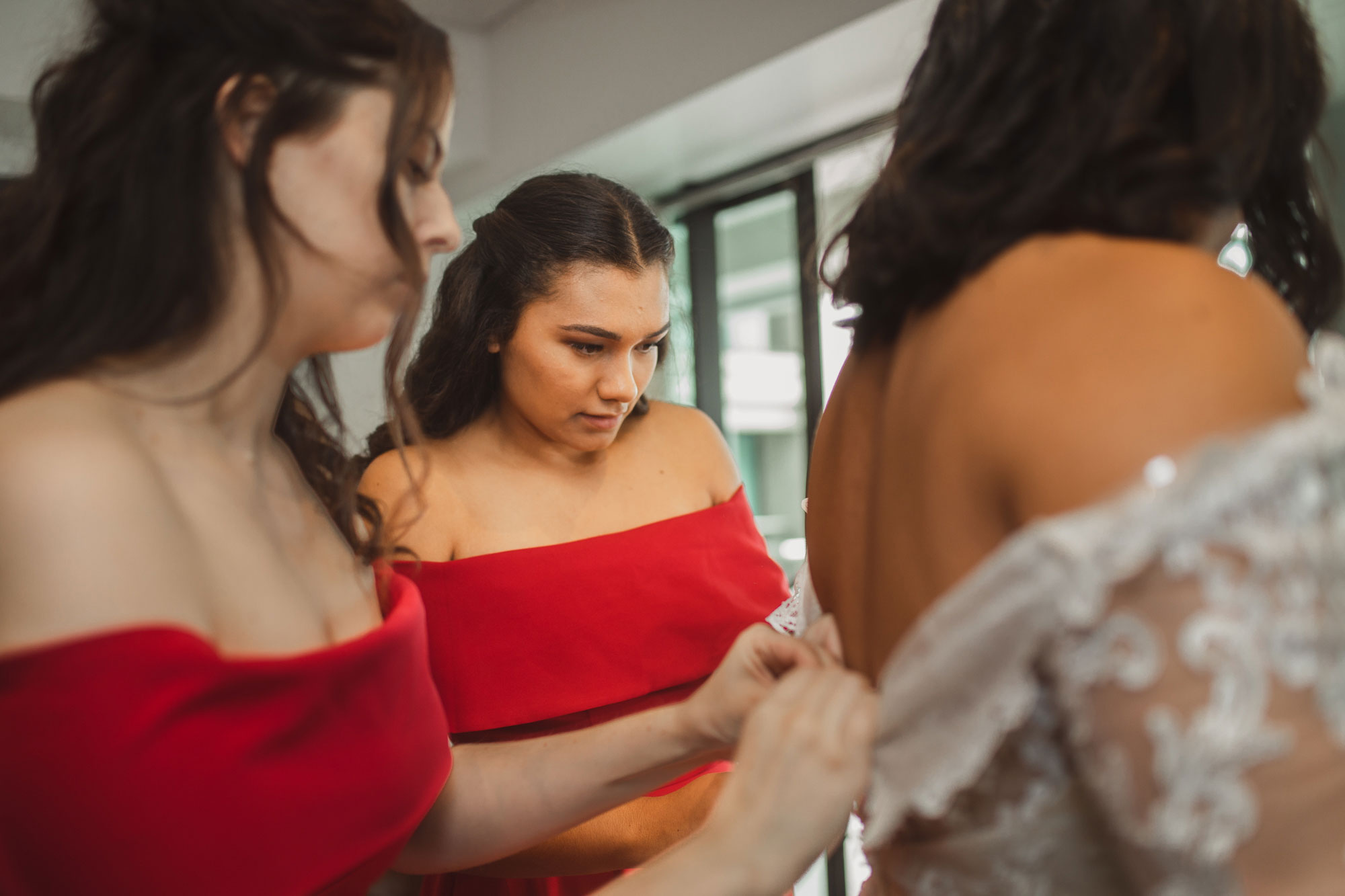 bridesmaids helping the bride with dress