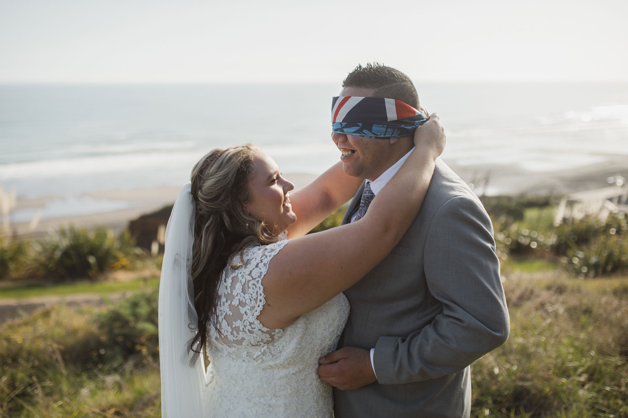 bride removing blindfold from groom during first look