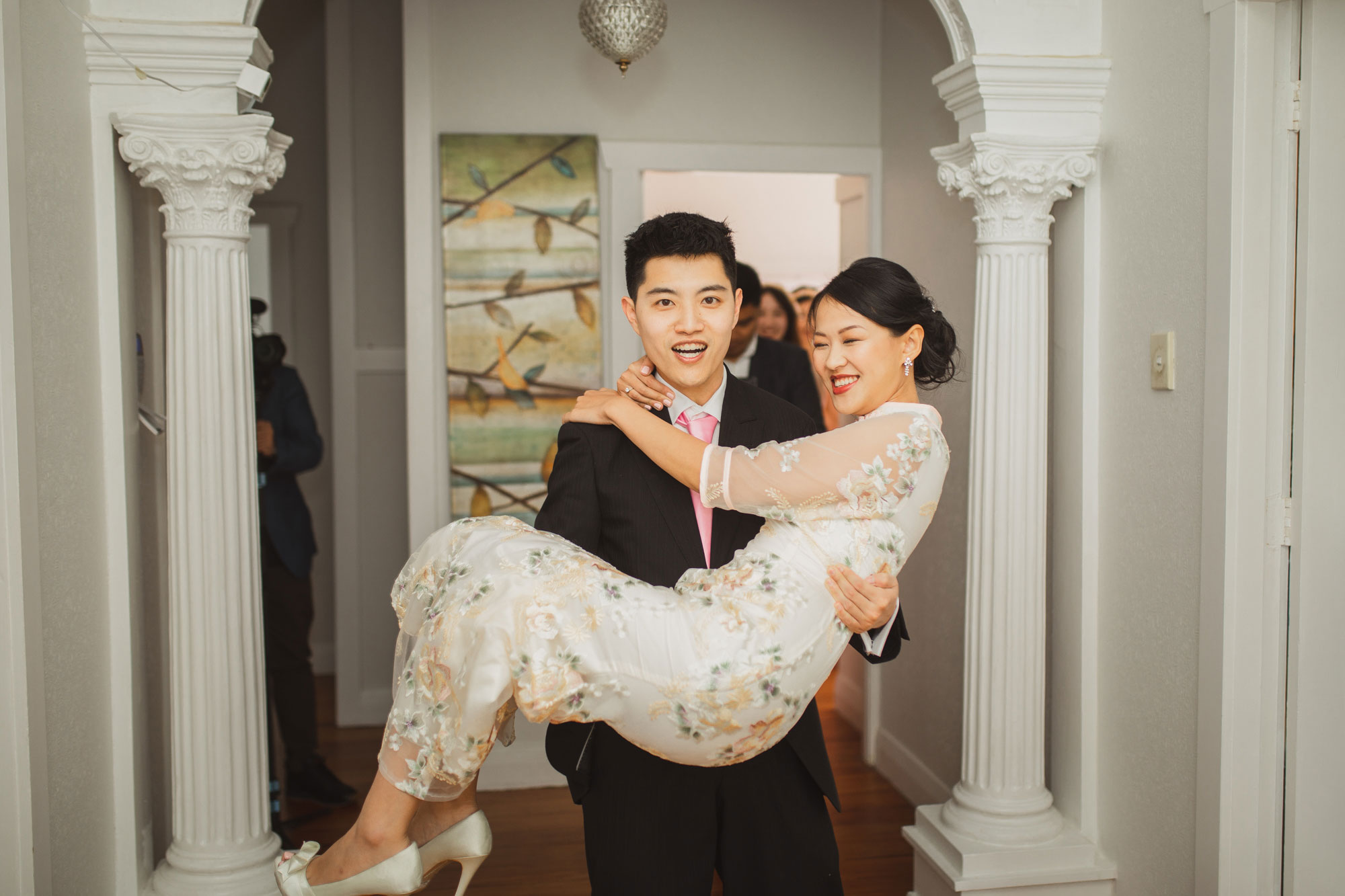 groom carrying bride out of the room