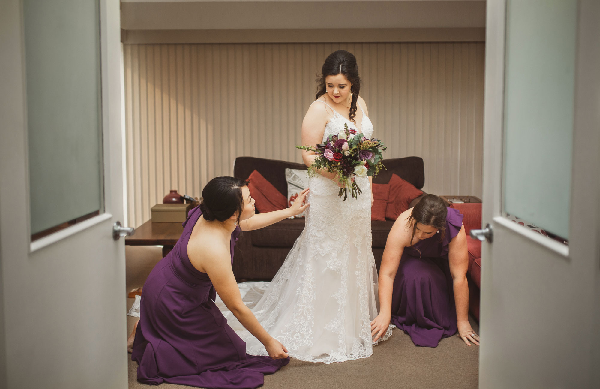 bridesmaids helping the bride with her dress