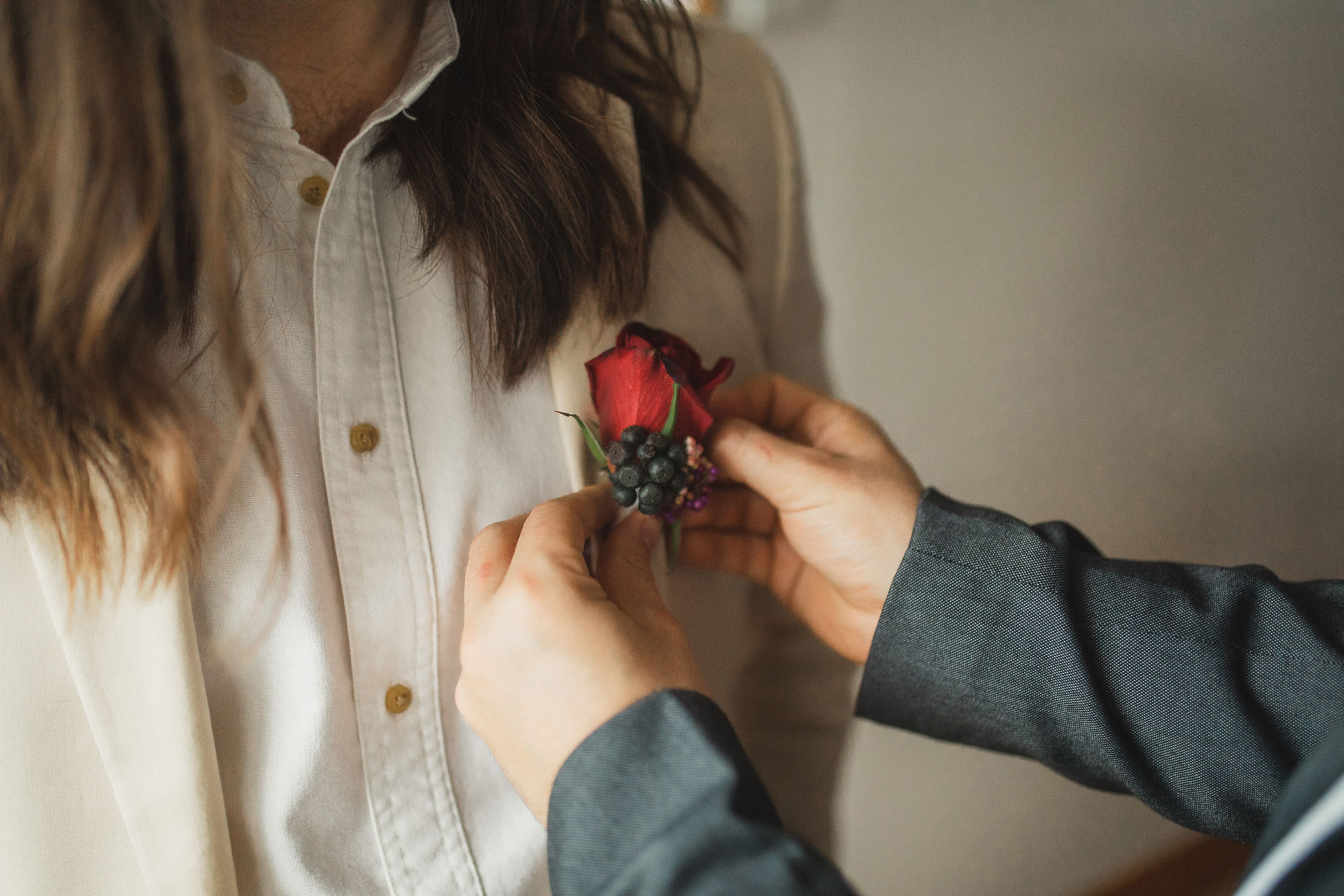 groom putting on flowers