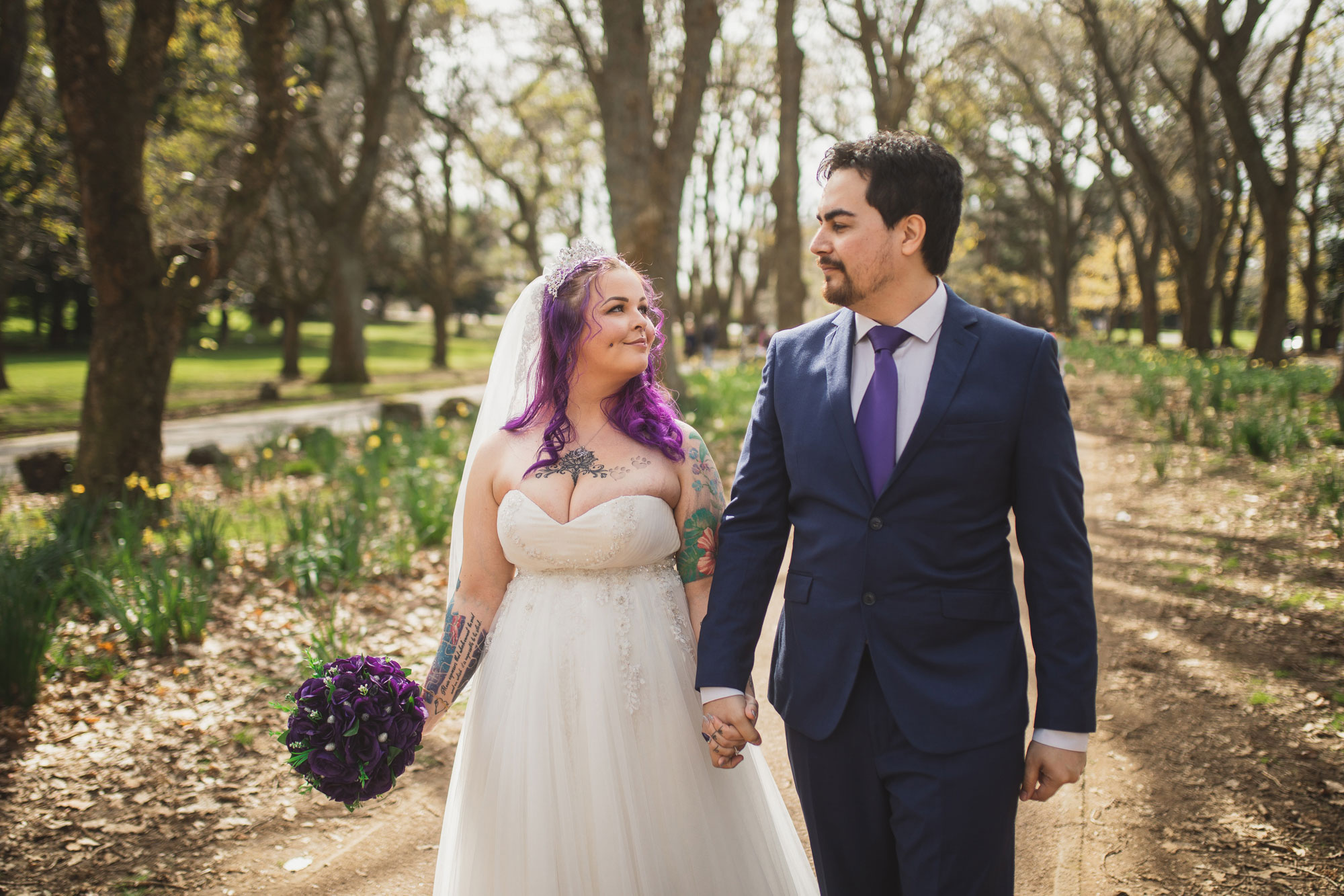 bride and groom walking in cornwall park auckland