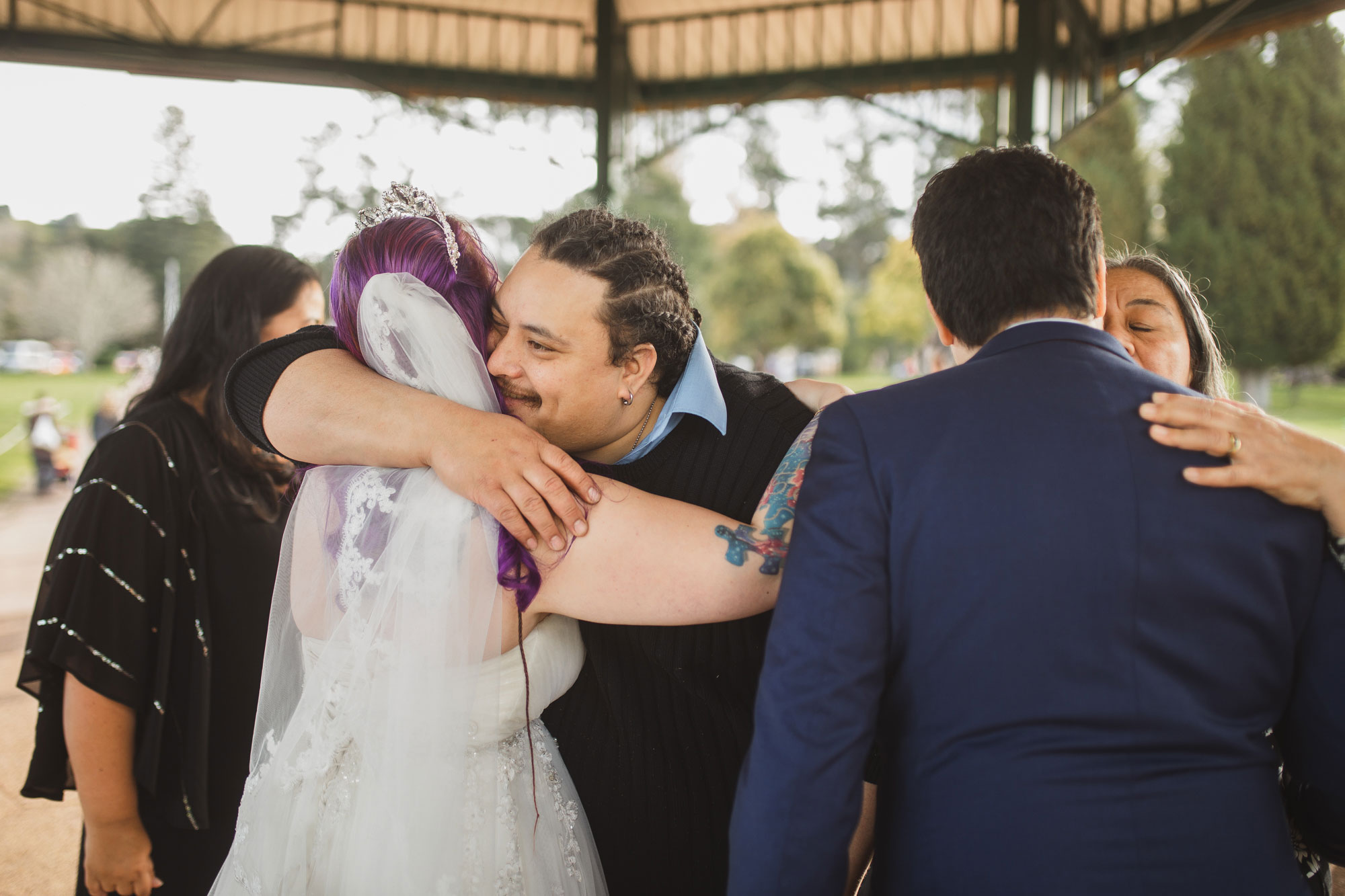 wedding guests hugging the bride