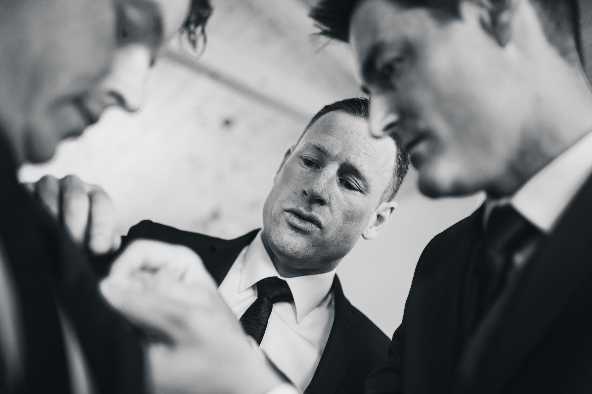 groomsmen putting on buttonhole