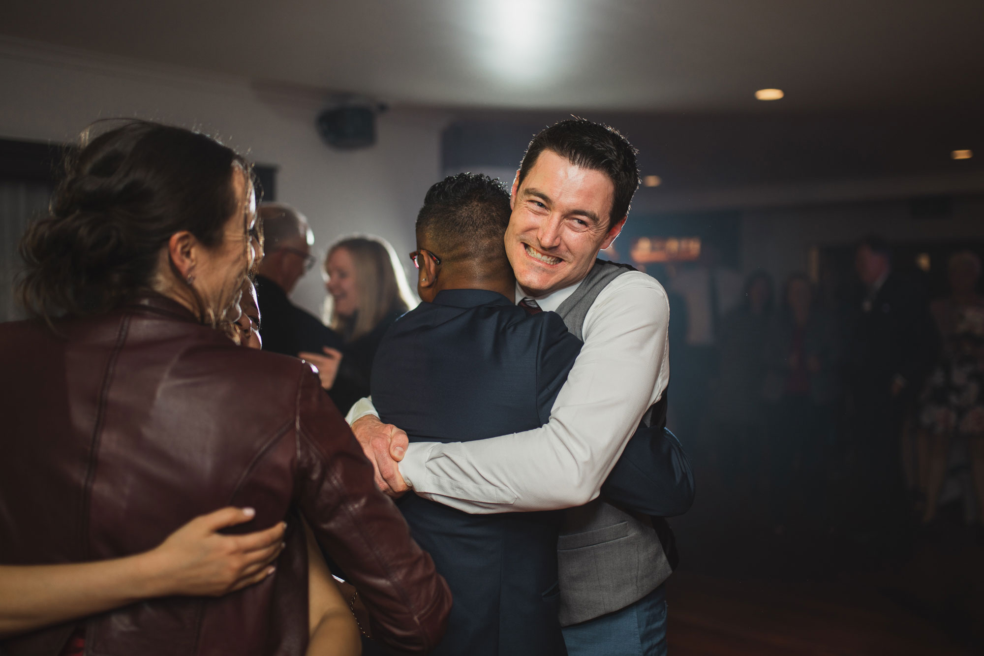 groom hugging a guest