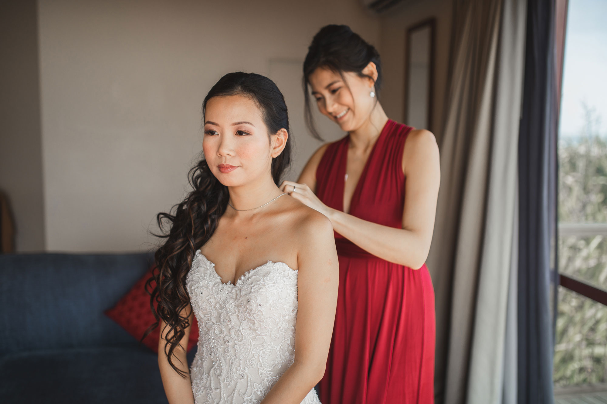 bride putting on necklace