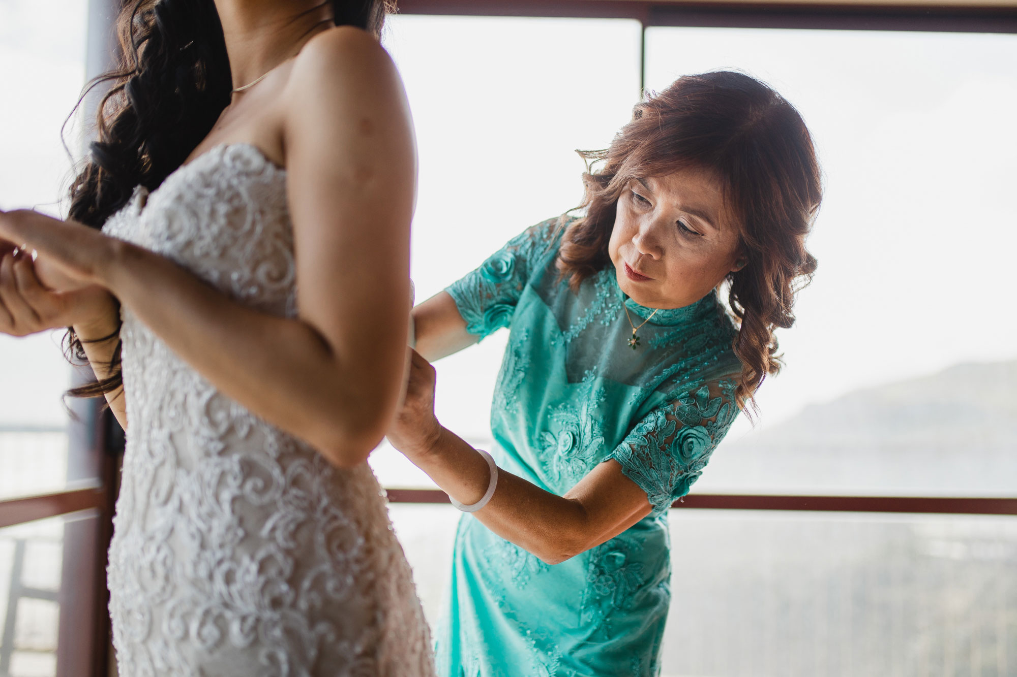 mother tying up brides dress