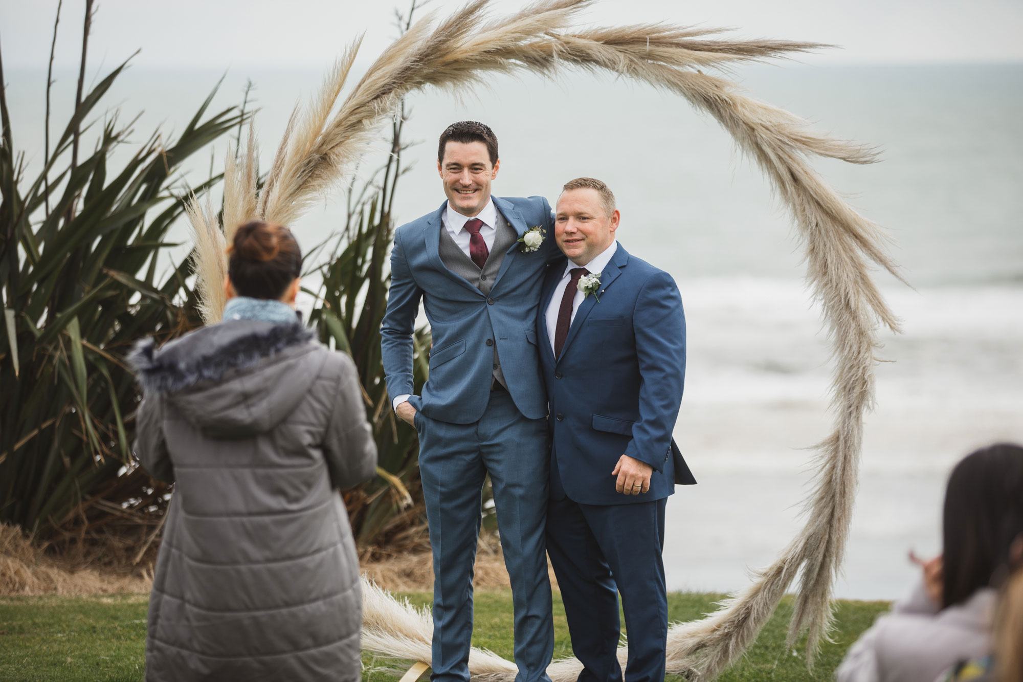 groom taking photo at the arch