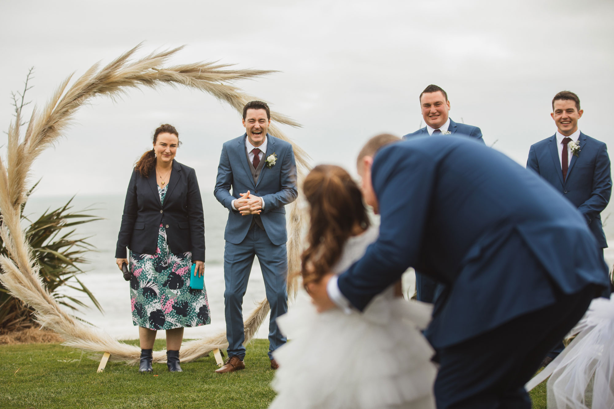 groom looking at the flowergirl