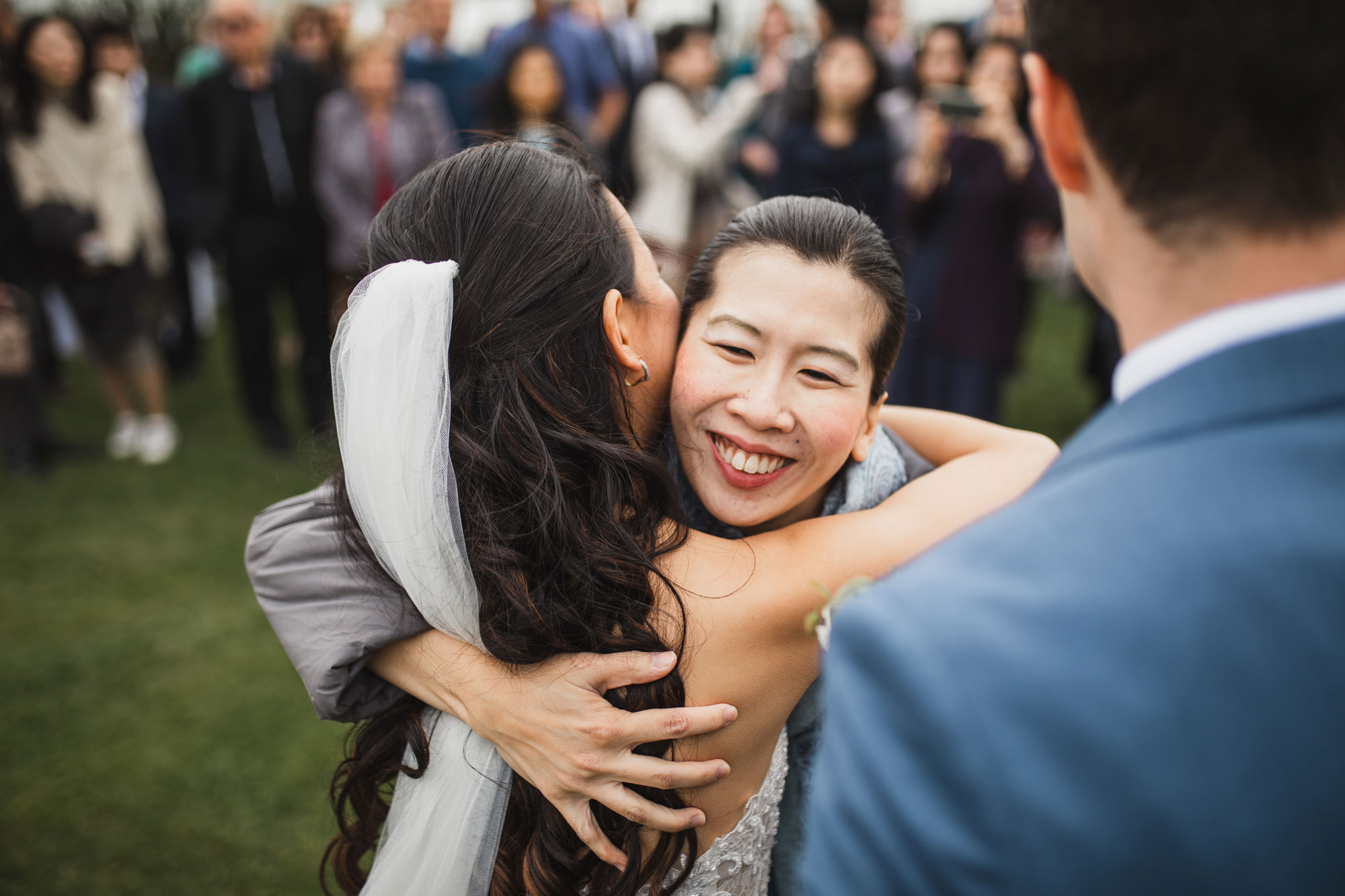 wedding guests hugging the bride