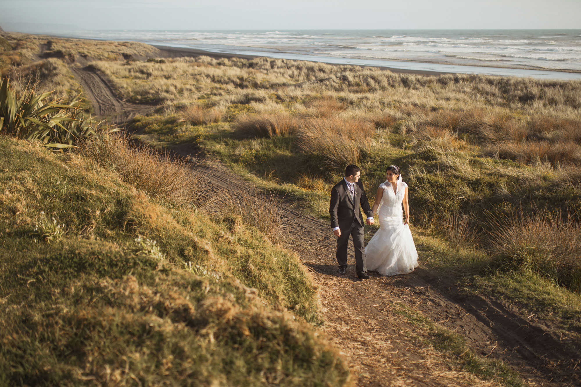 bride and groom strolling alone the beach