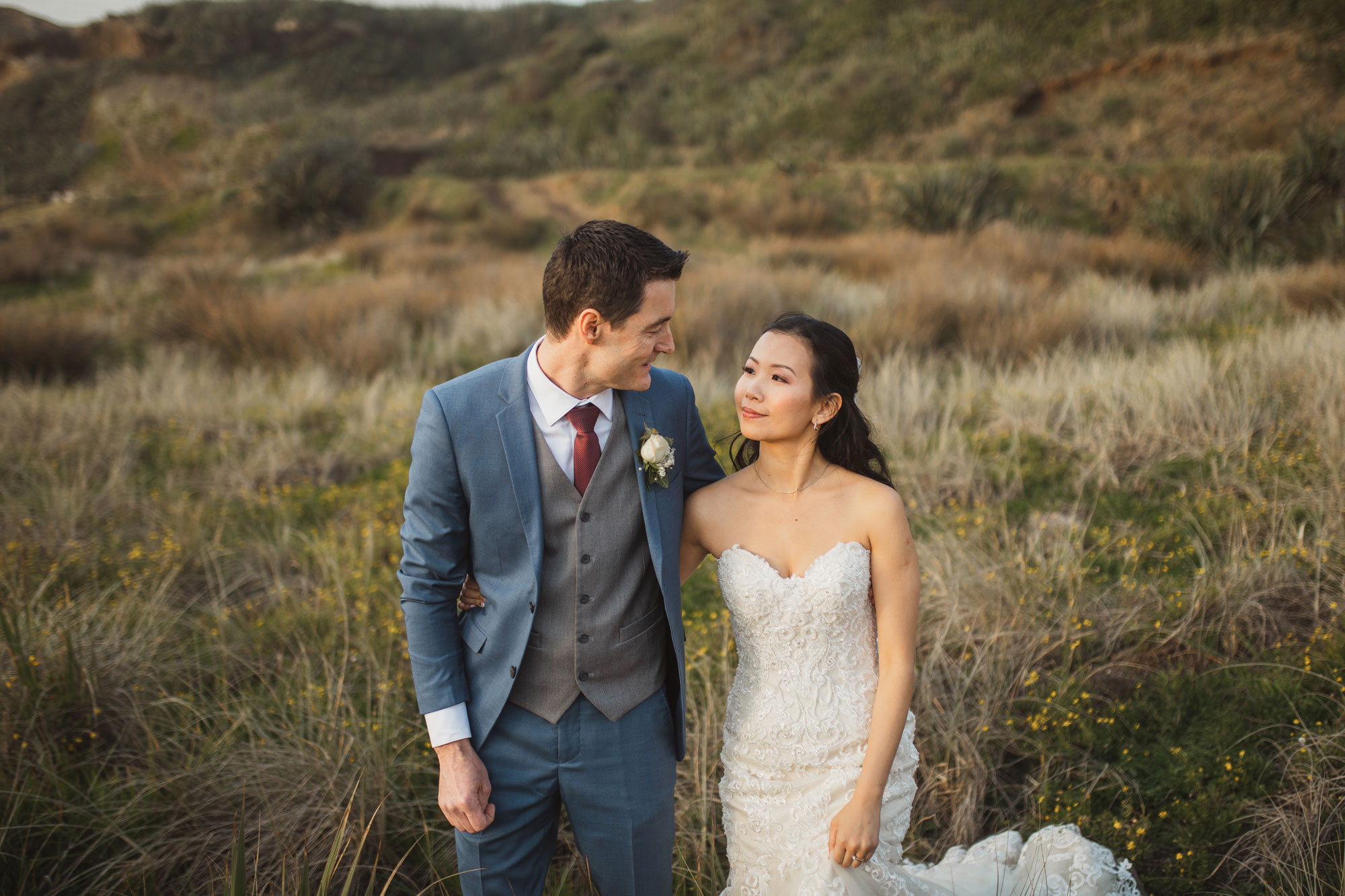 bride and groom walking on the dunes