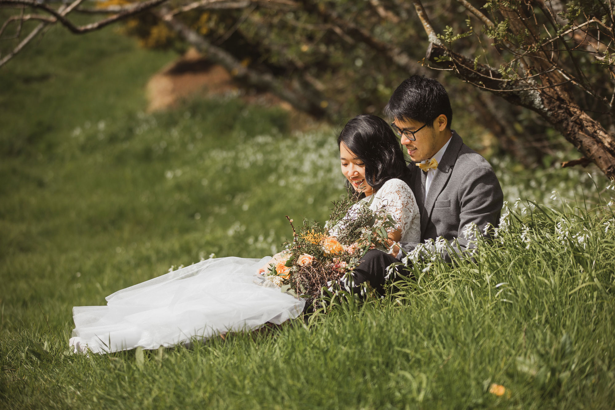 bide and groom sitting on grass