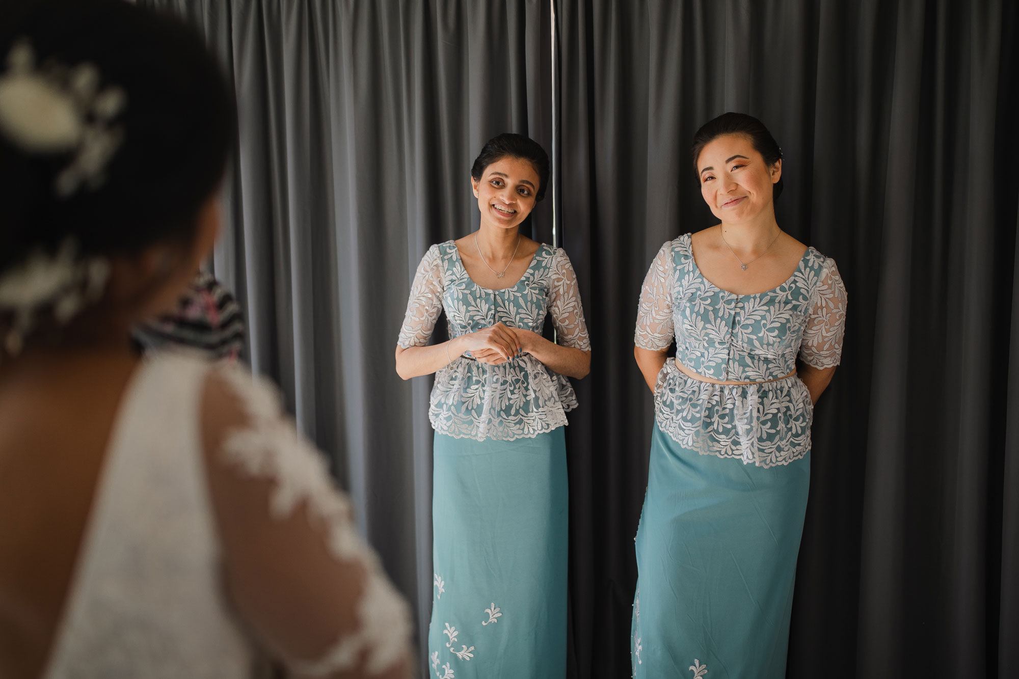 bridesmaids admiring bridal dress