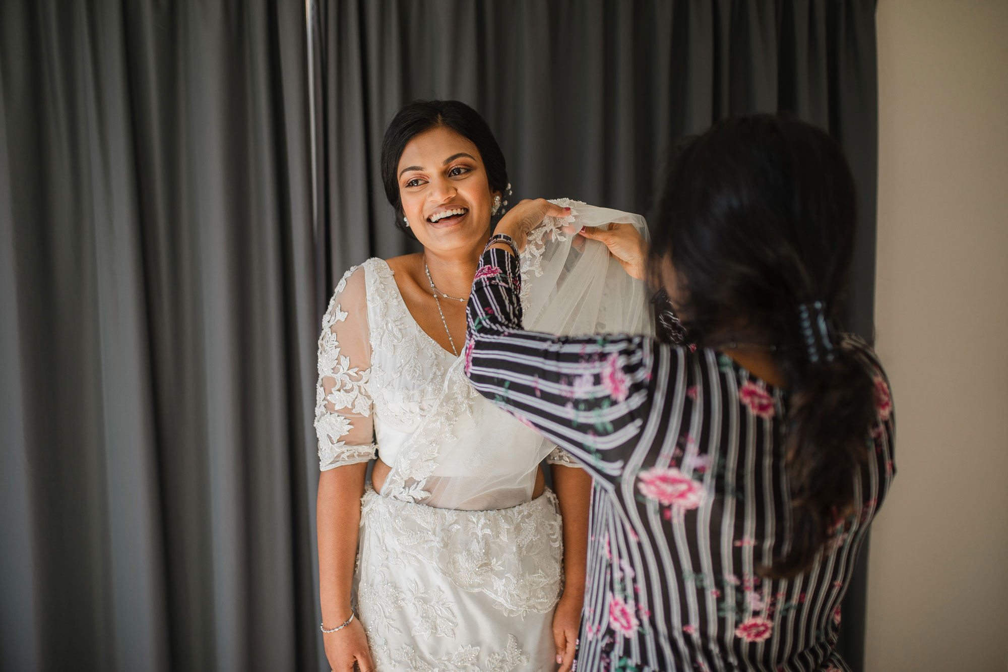 bride putting on traditional wedding dress