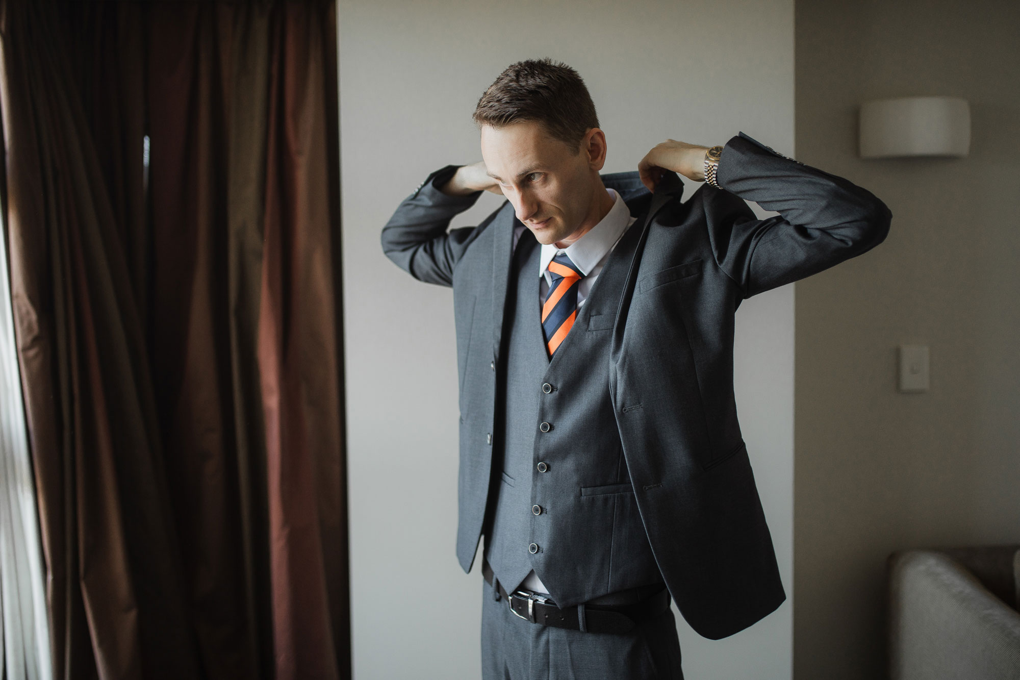 groom putting on suit