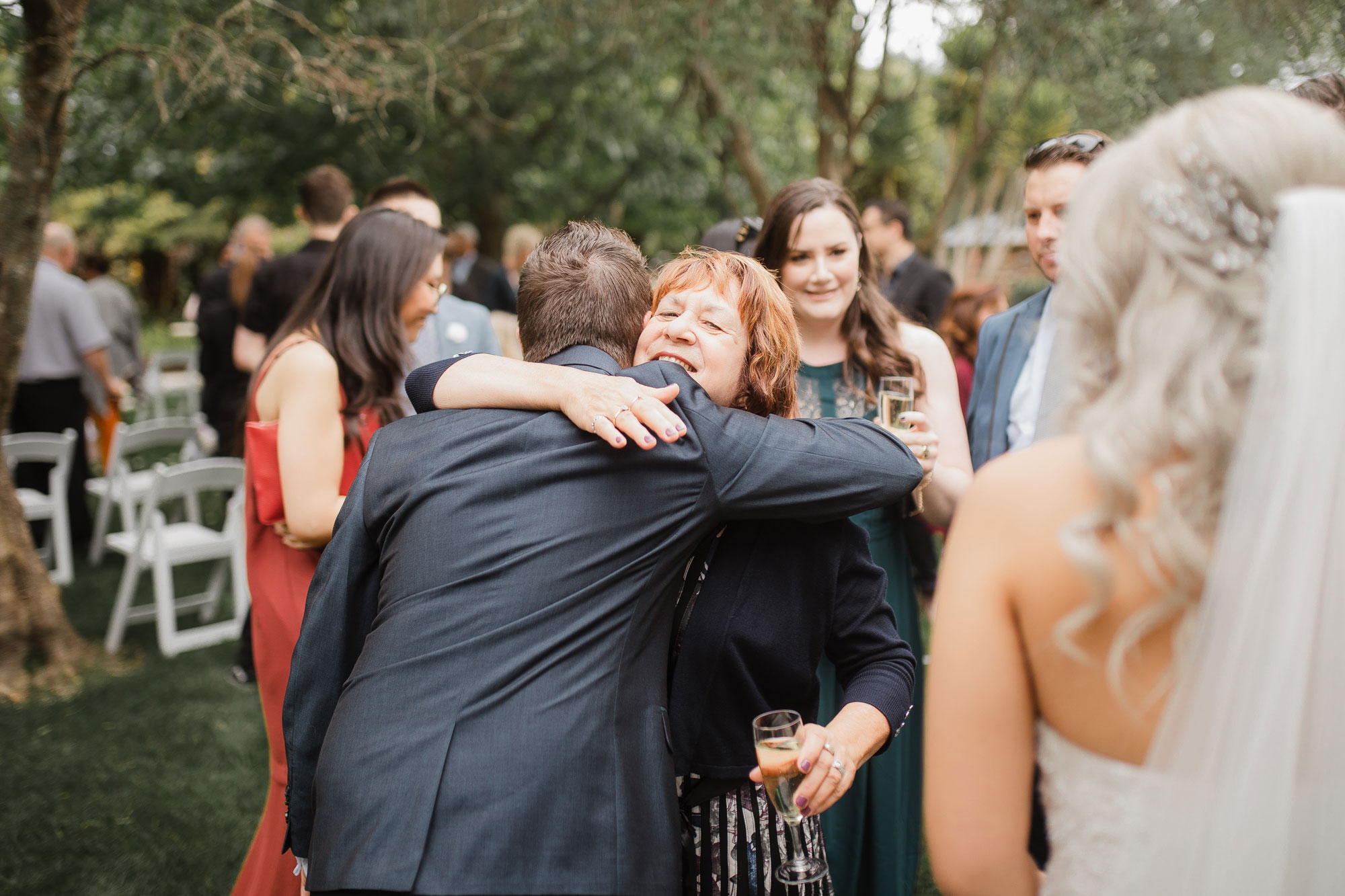 wedding guests hugging the groom