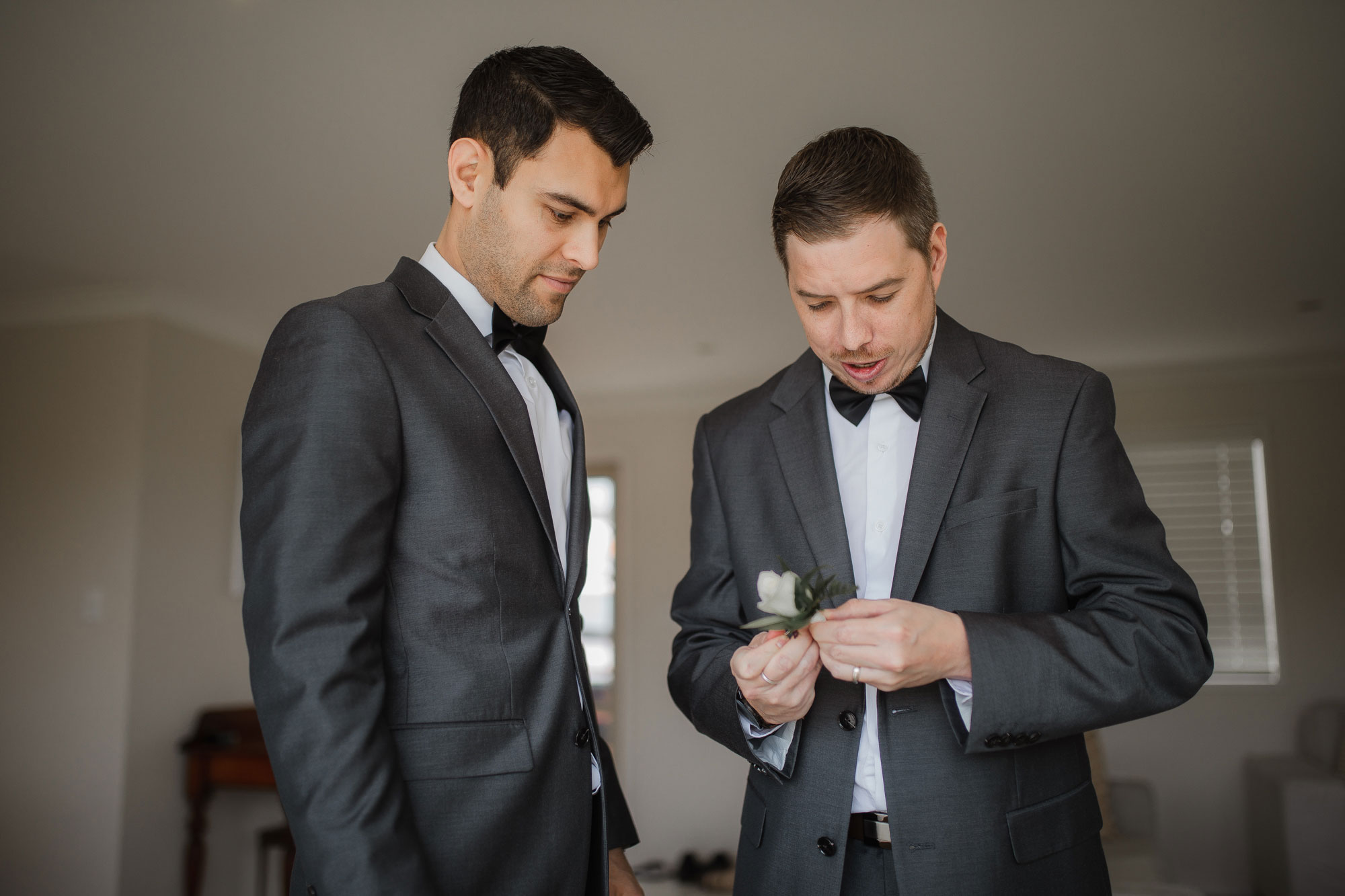 groomsmen putting on buttonhole