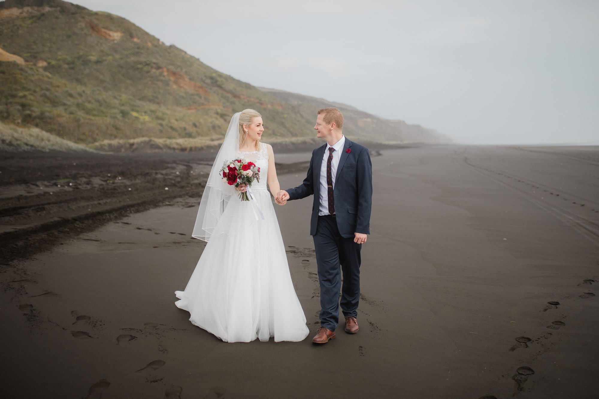 bride and groom walking on the beach