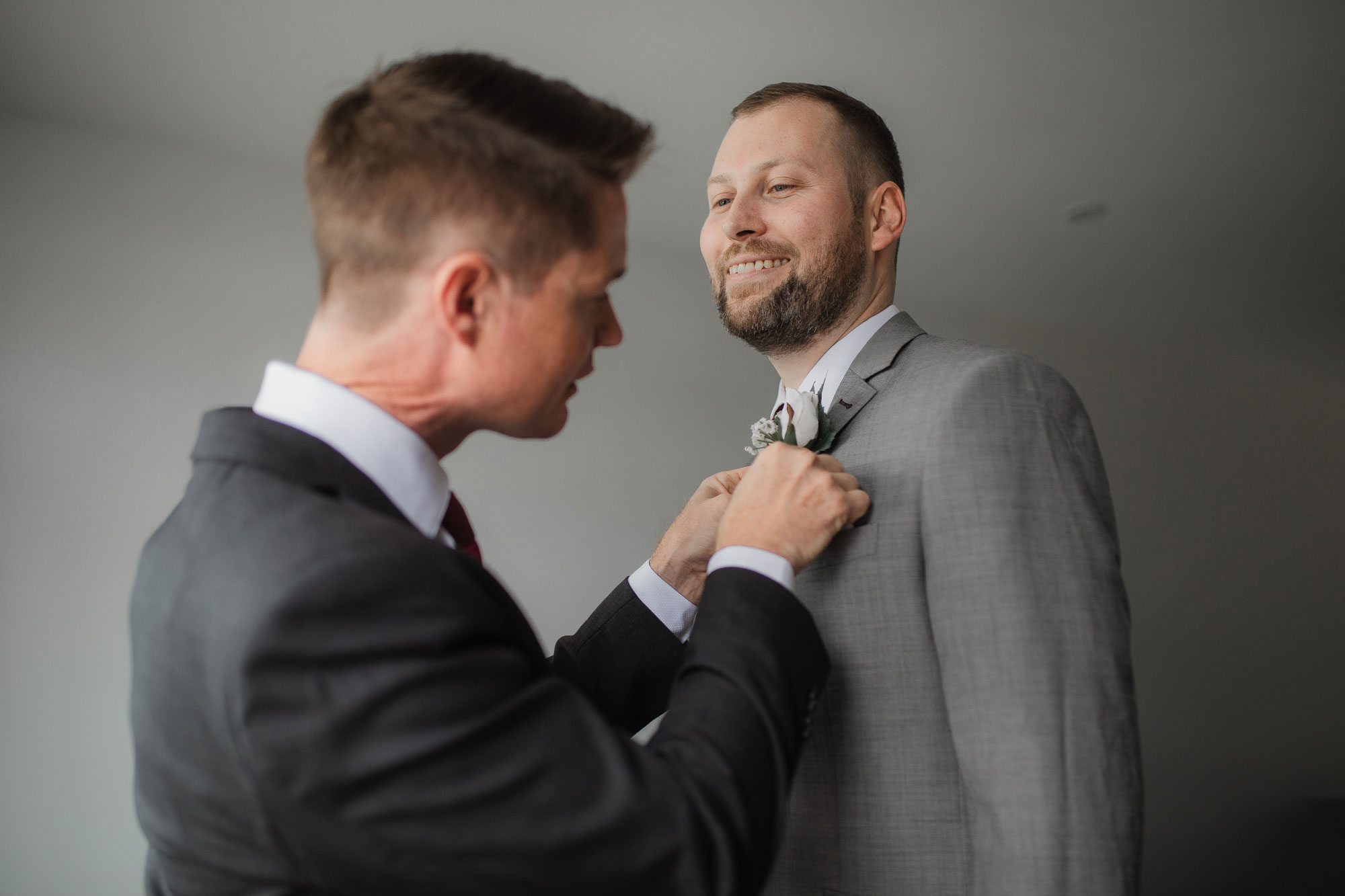 groom putting on buttonhole