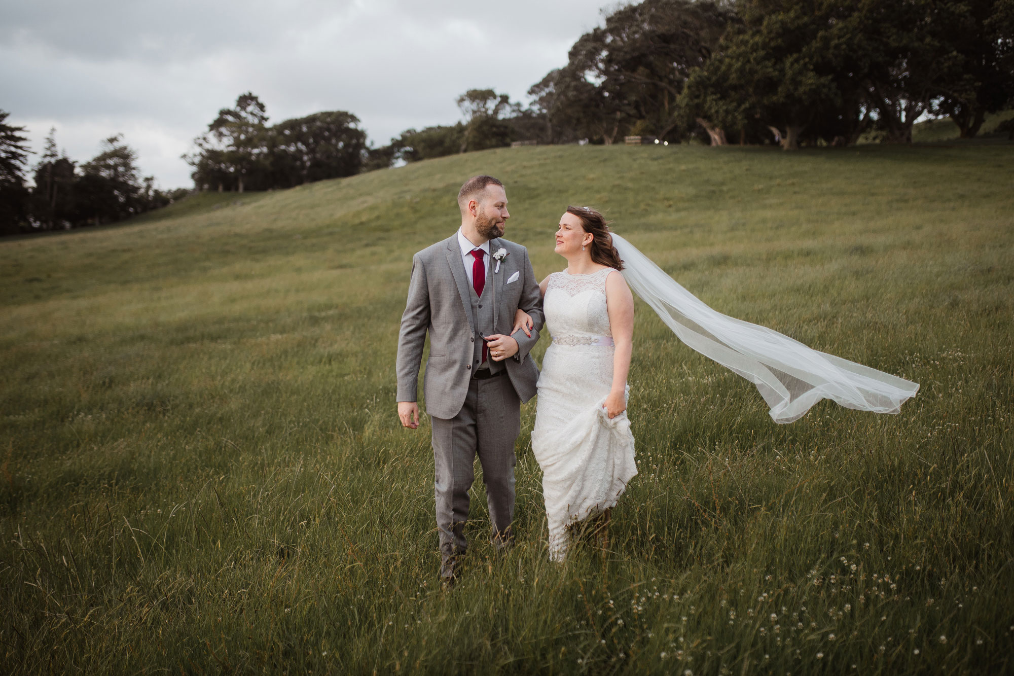 bride and groom strolling in cornwall park