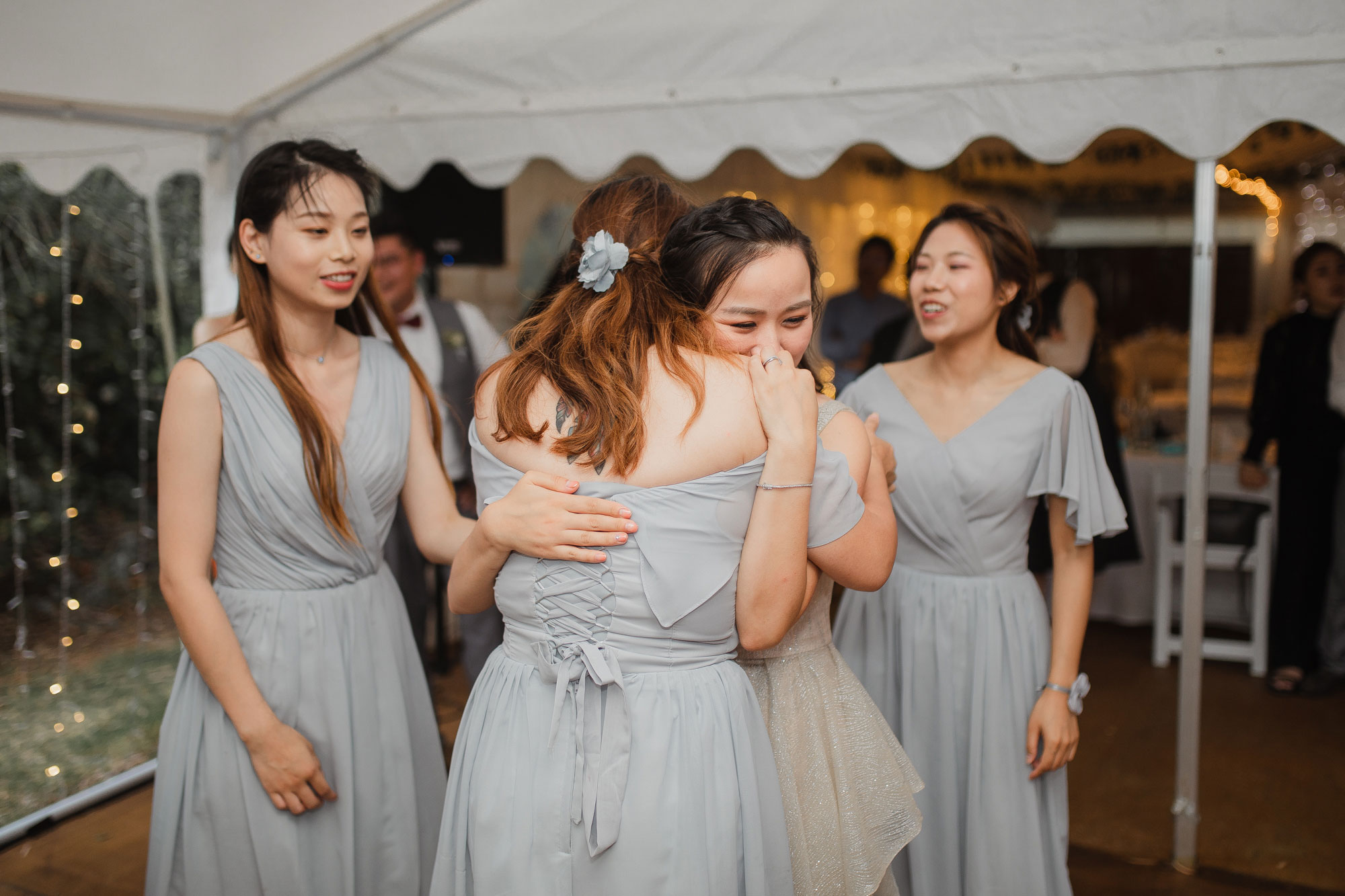 bride hugging bridesmaids crying