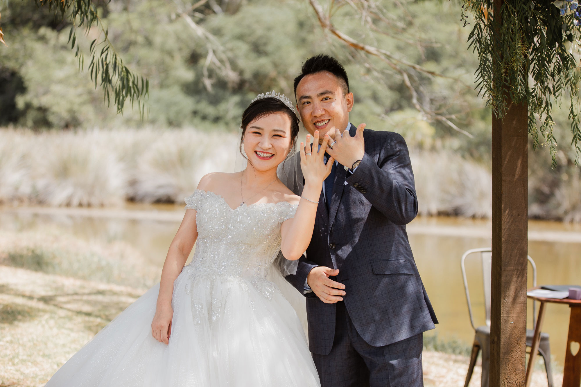 bride and groom showing off rings