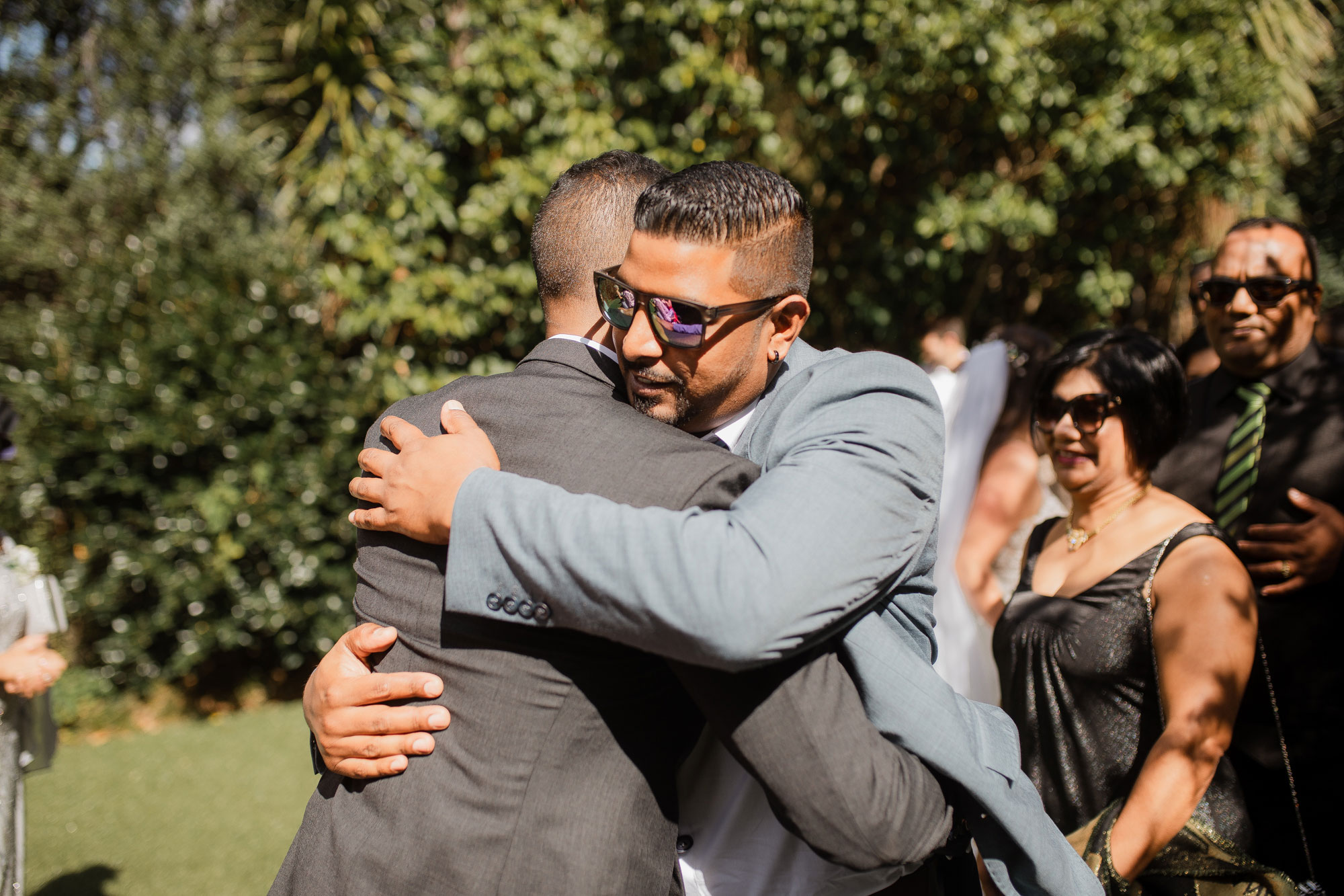 wedding guests hugging the groom