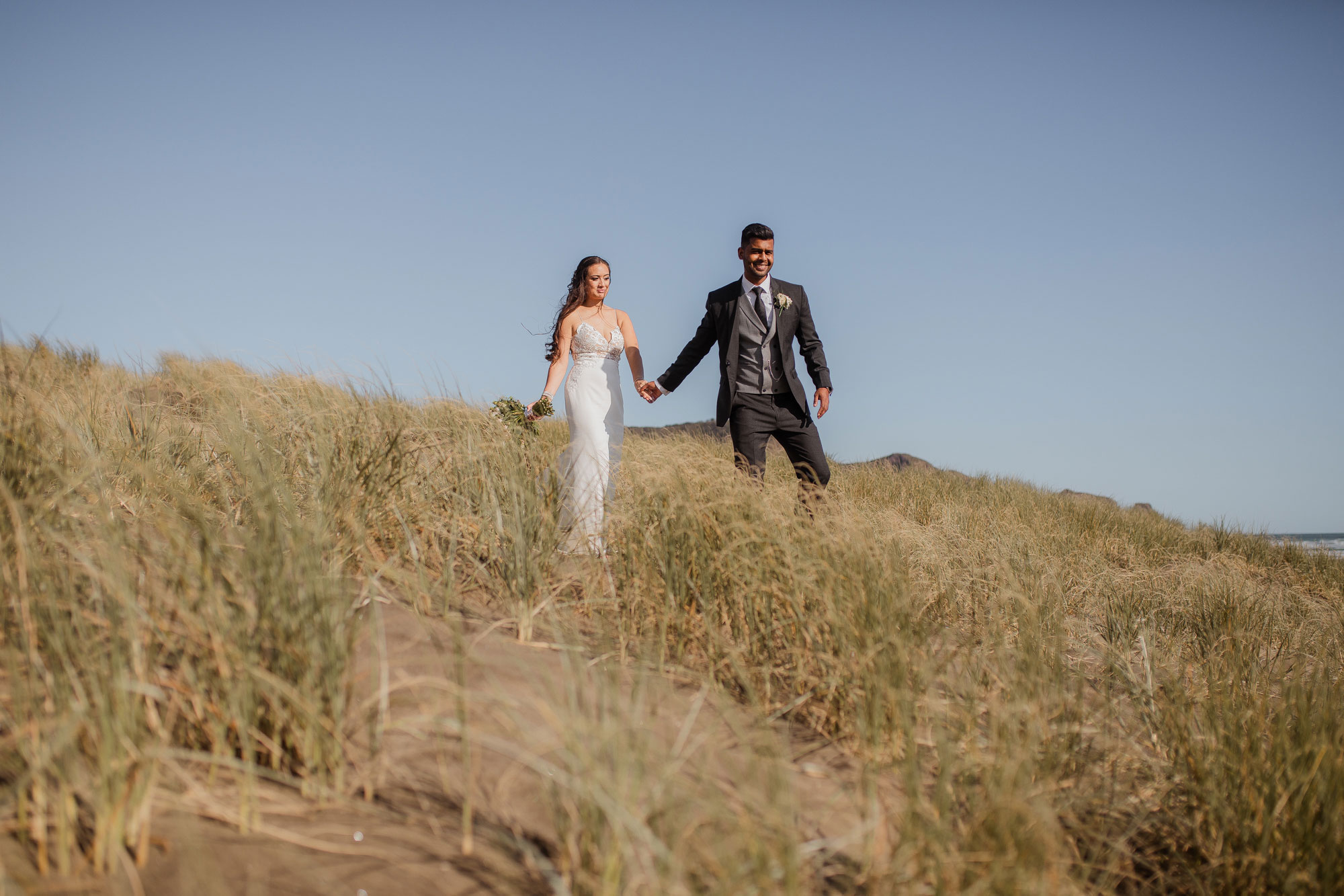 bride and groom at bethells beach