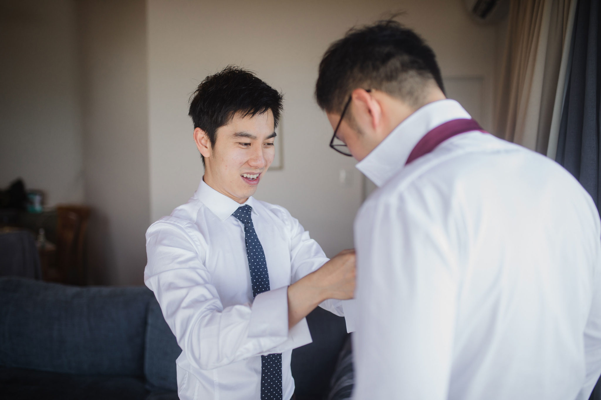 groom putting on tie