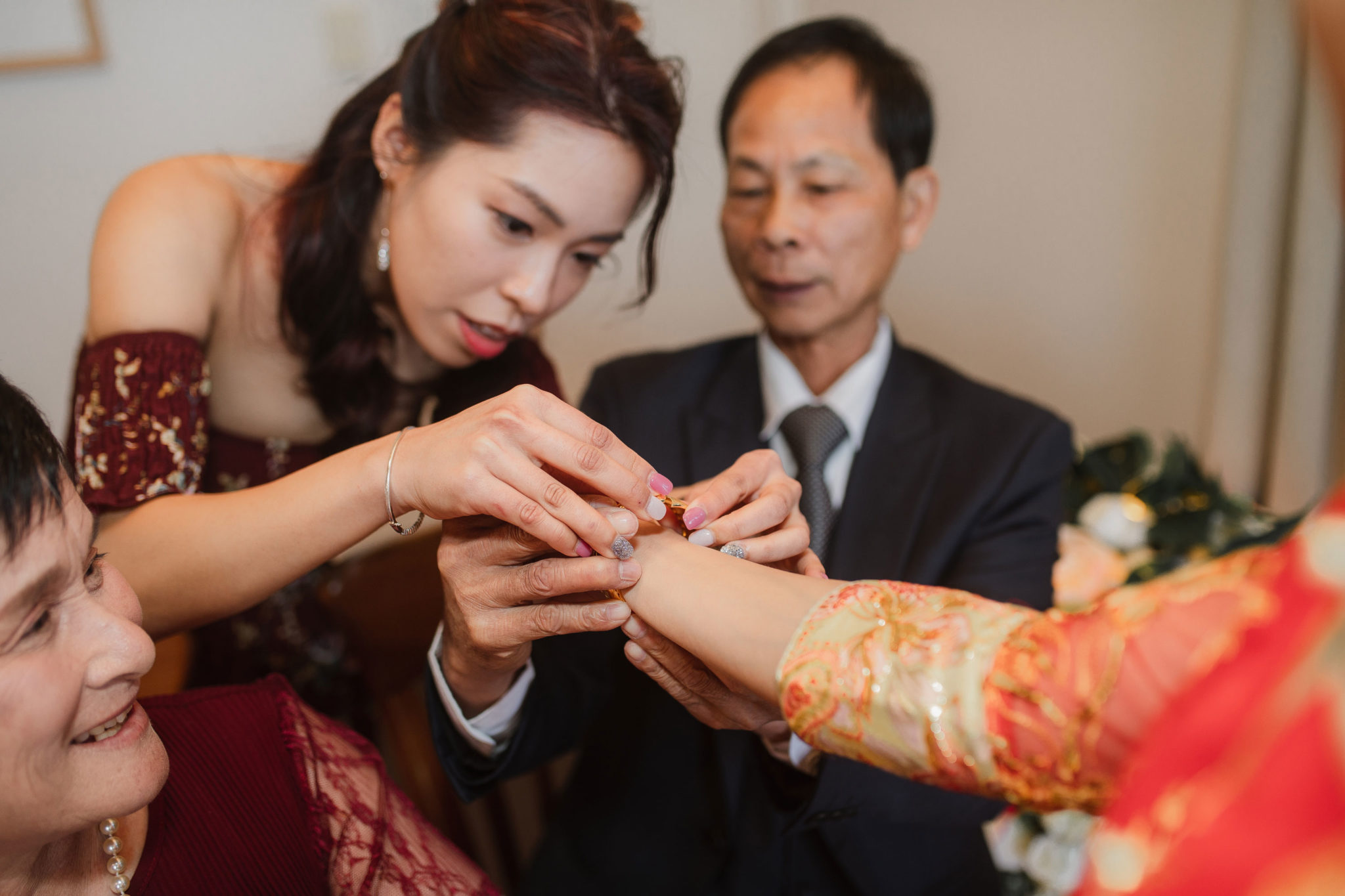 putting on gold bracelet for bride