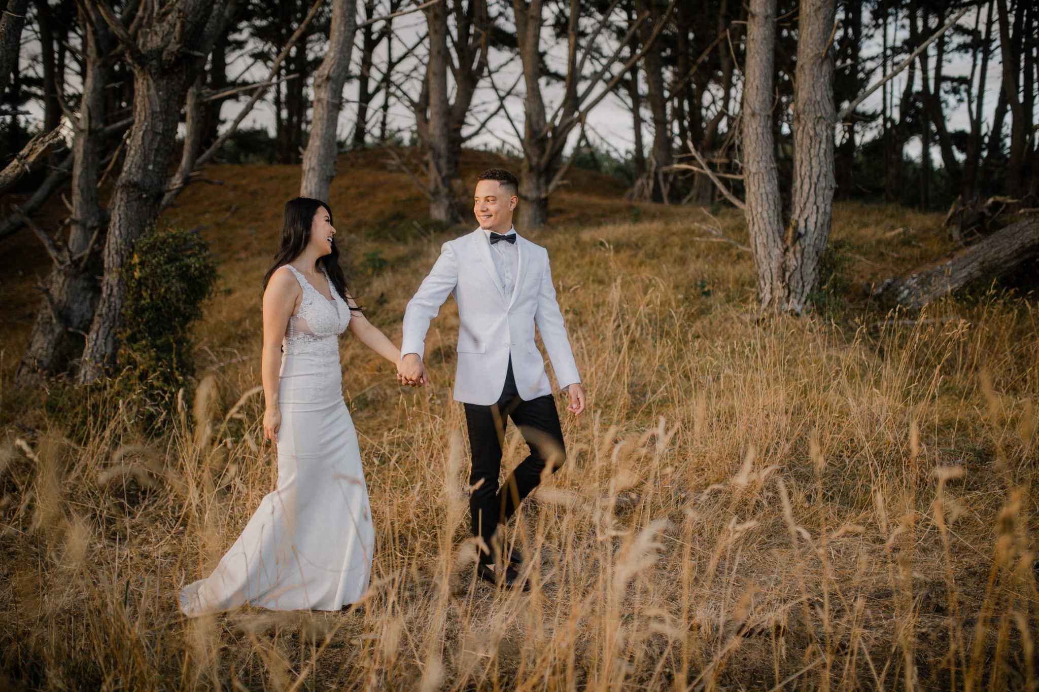 couple walking muriwai beach