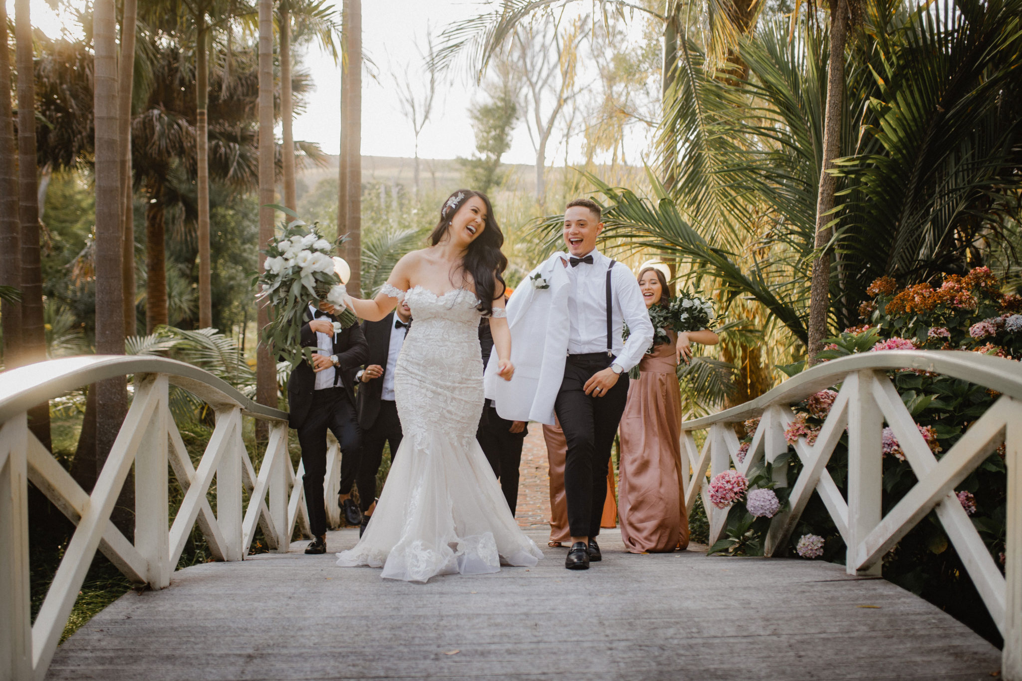 bridal party dancing across the bridge