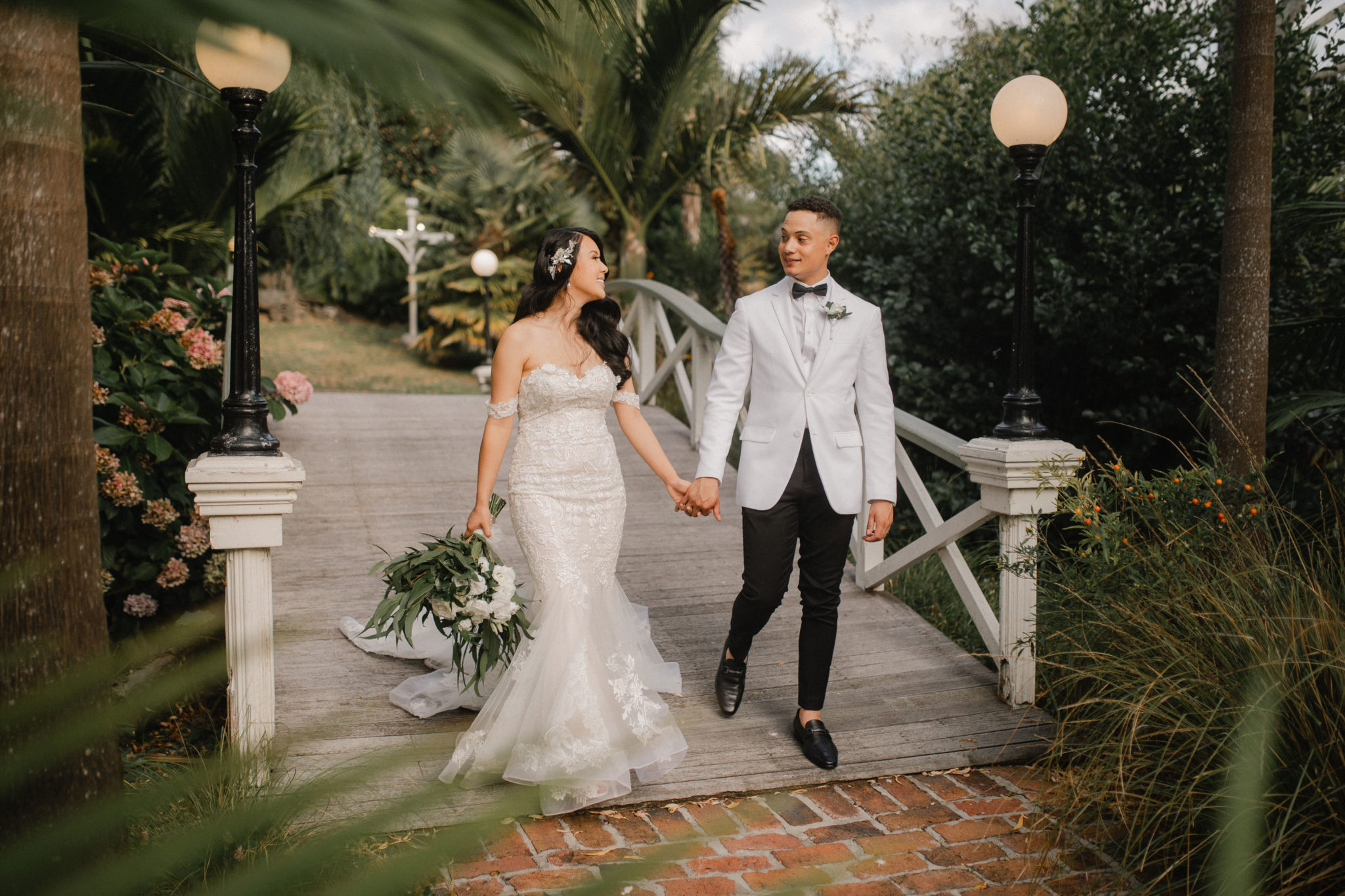 bride and groom walking across the bridge